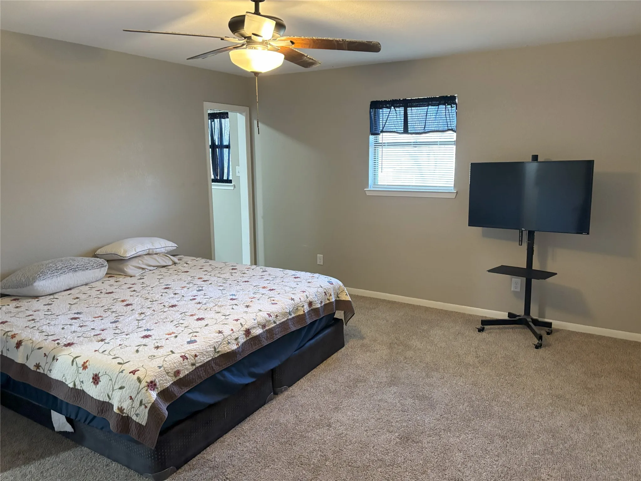 Carpeted bedroom with ceiling fan
