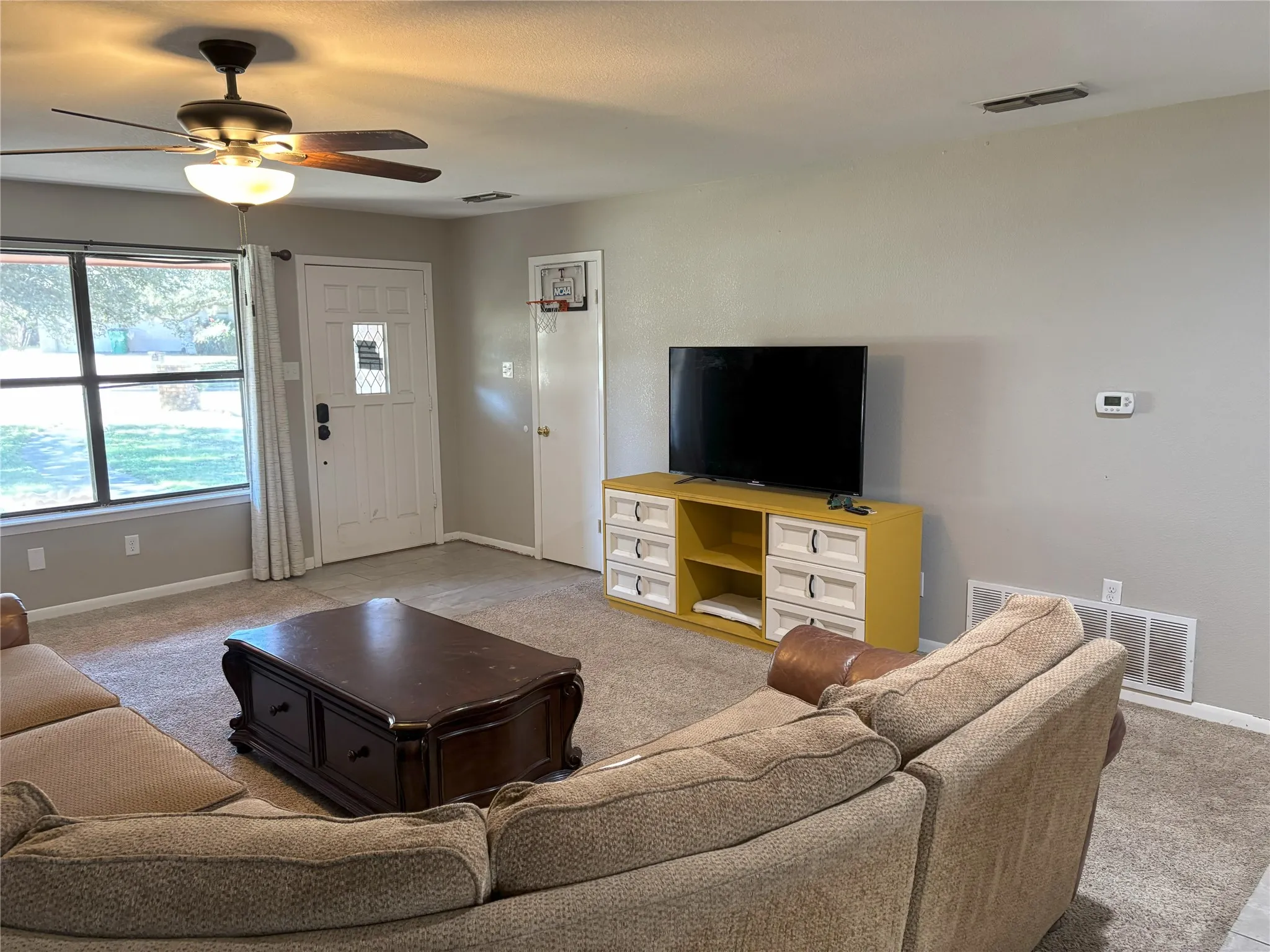 Living room with light colored carpet and ceiling fan