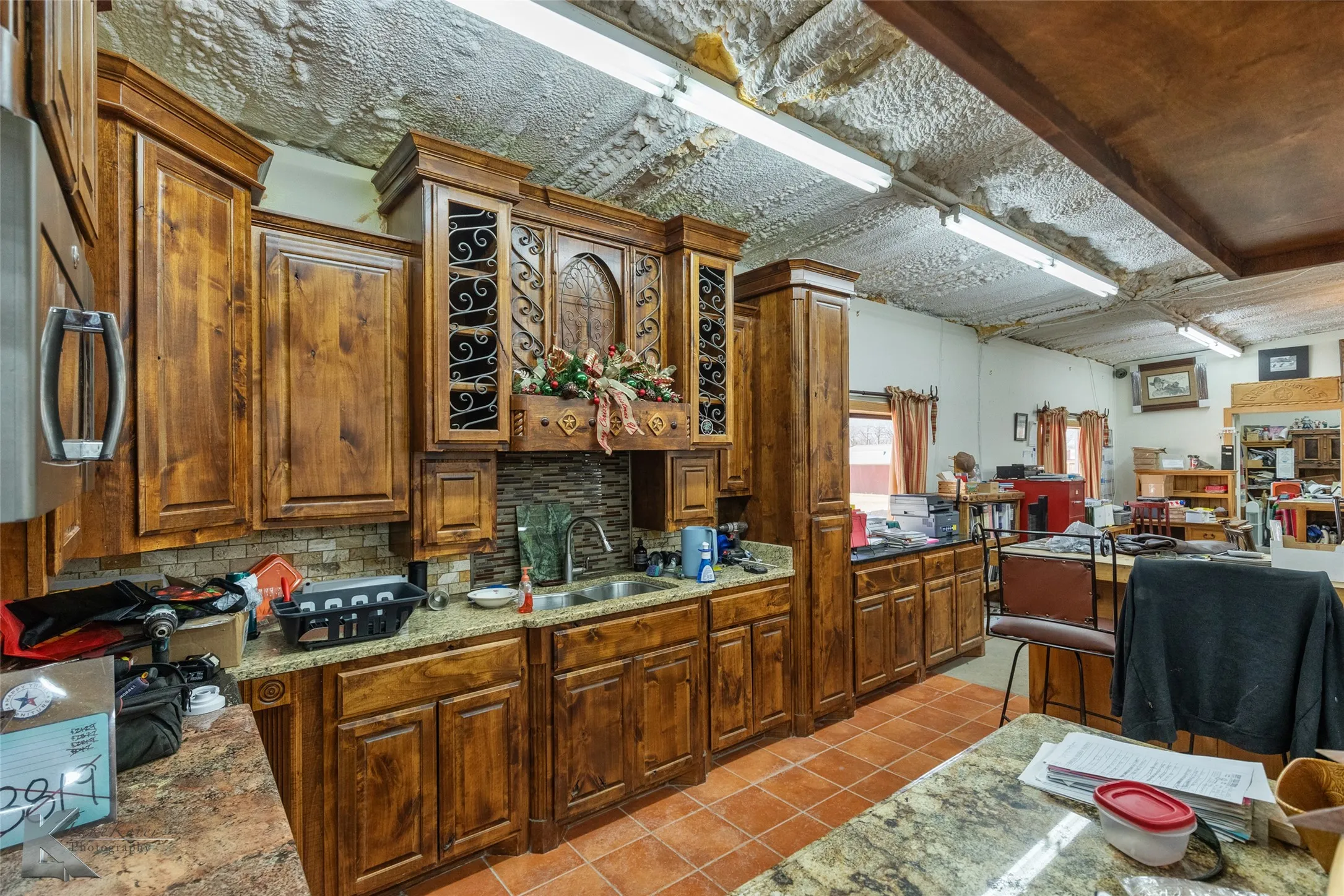 Kitchen featuring light stone countertops, sink, decorative backsplash, and light tile patterned floors