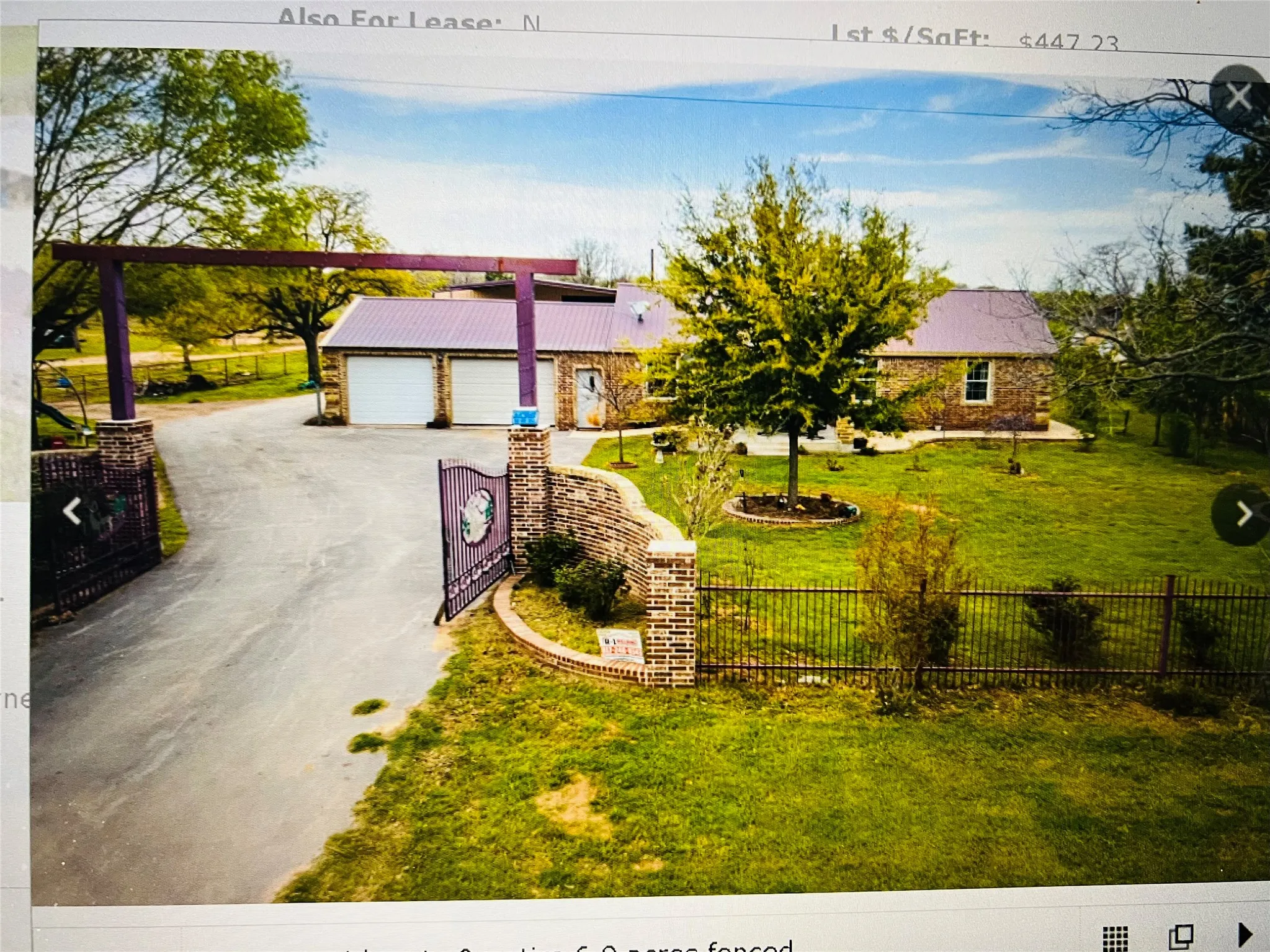 Mid-century home with metal roof, a garage, and driveway