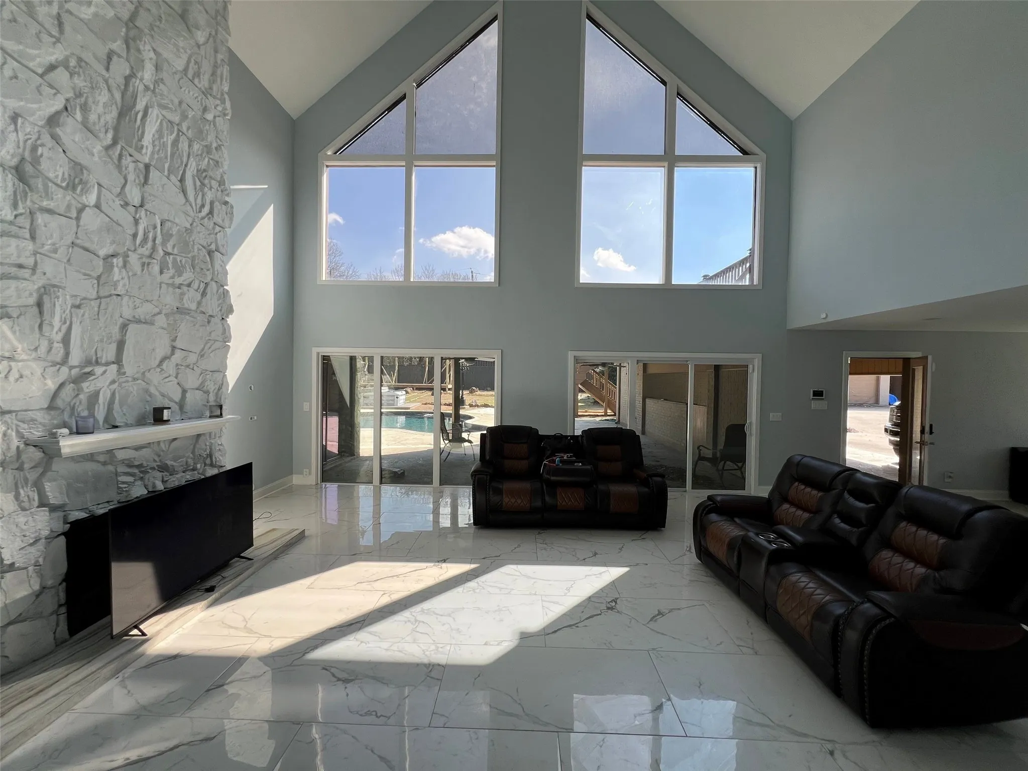 Living room with vaulted ceiling and a large fireplace