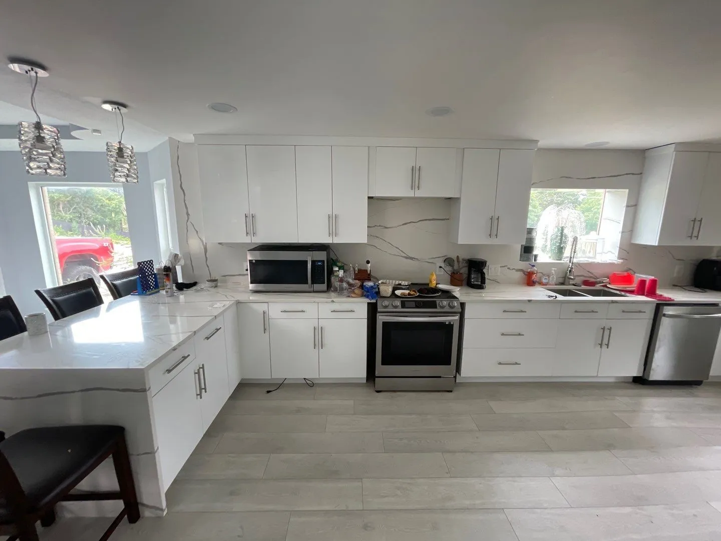 Kitchen featuring hanging light fixtures, white cabinetry, appliances with stainless steel finishes, and sink