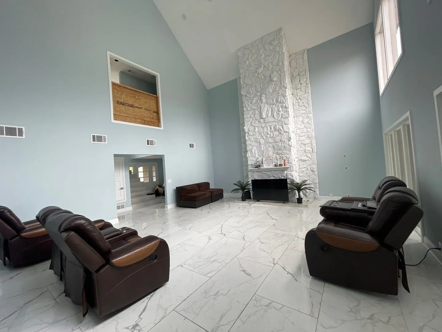 Living room with a fireplace and a high ceiling