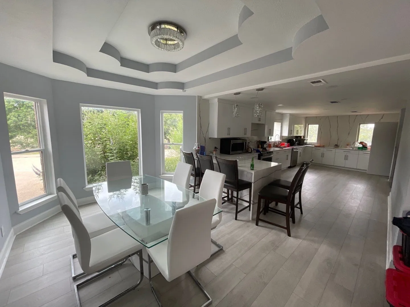 Dining space featuring plenty of natural light, light hardwood / wood-style floors, and a tray ceiling