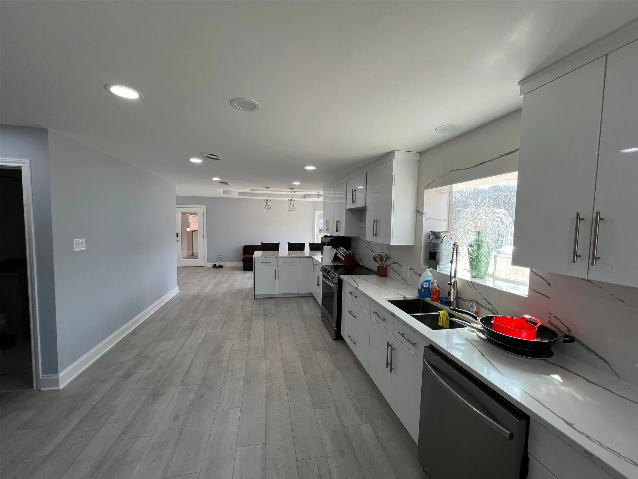 Kitchen featuring white cabinetry, sink, stainless steel appliances, and light wood-type flooring
