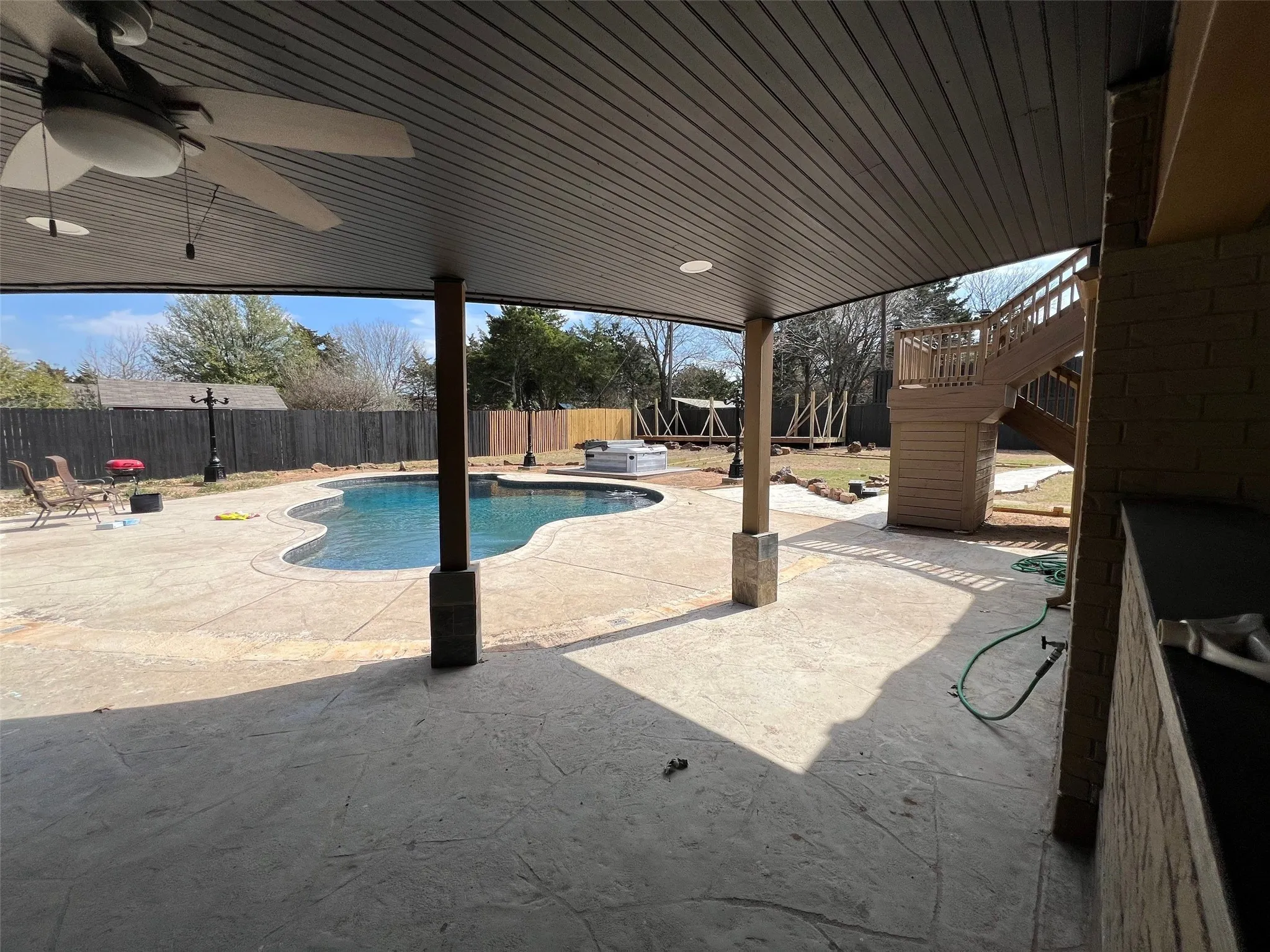 View of pool with ceiling fan and a patio