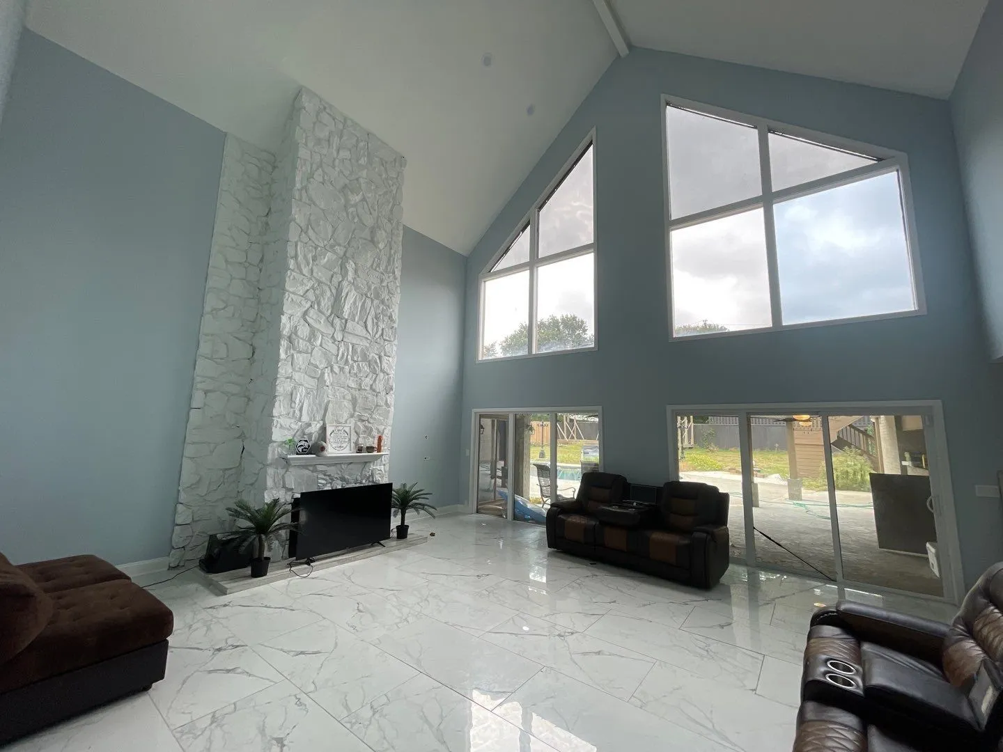 Living room with lofted ceiling, plenty of natural light, and a fireplace