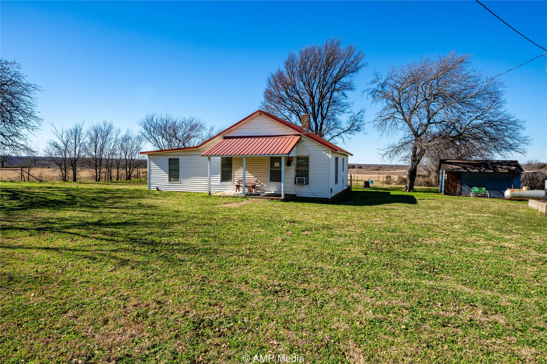 Back of house with covered porch and a lawn