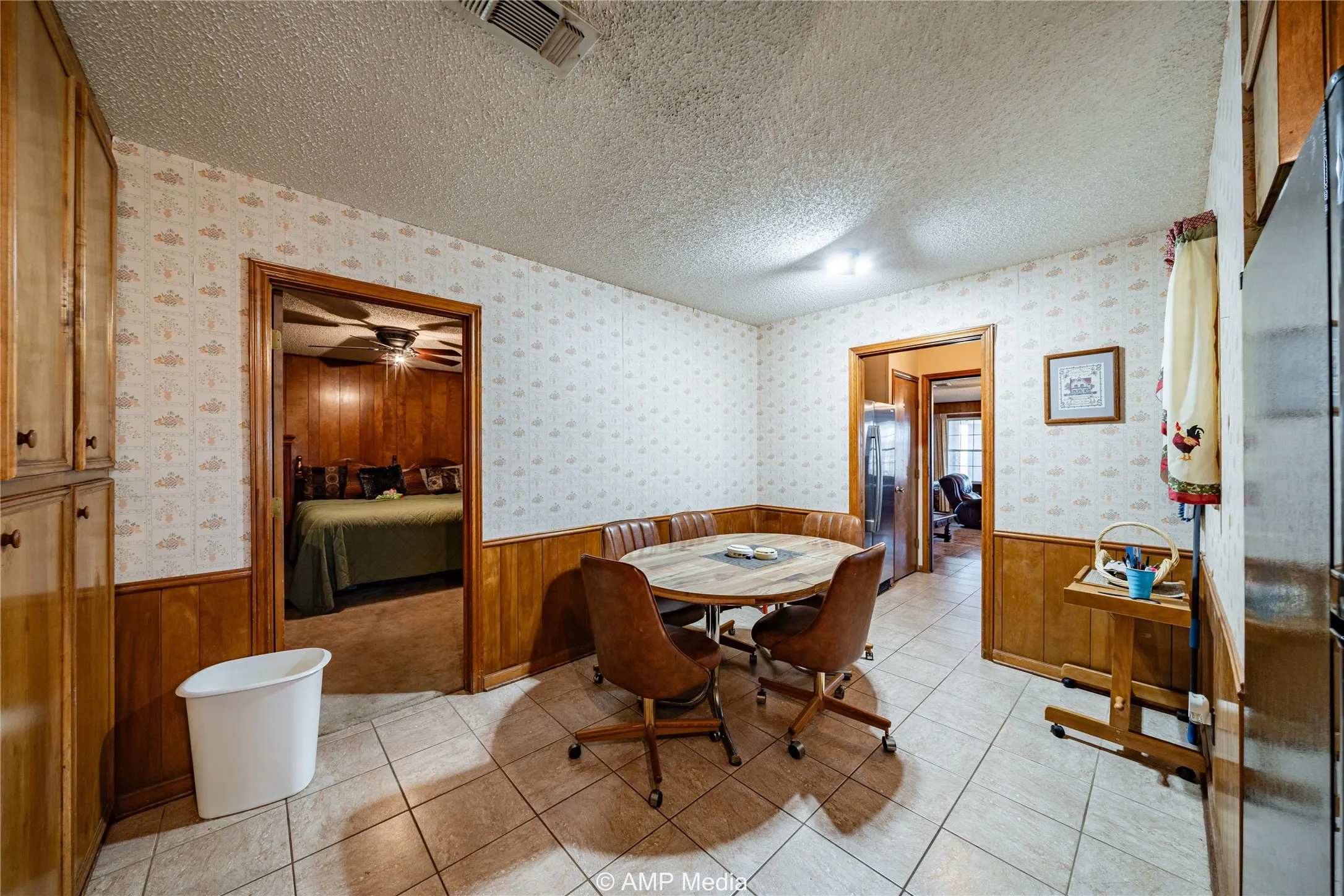 Dining area featuring ceiling fan, light tile patterned floors, and a textured ceiling