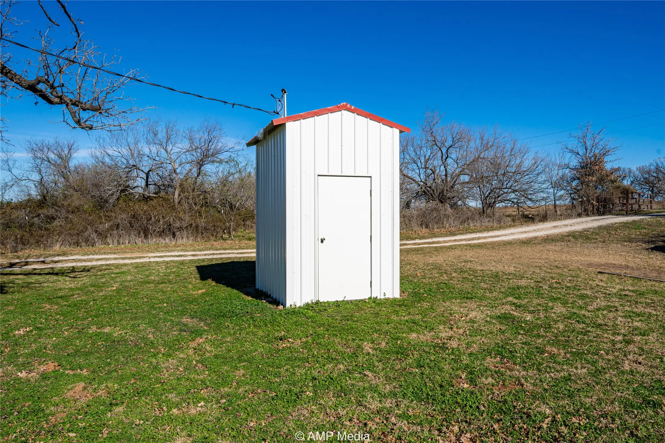 View of outdoor structure featuring a lawn