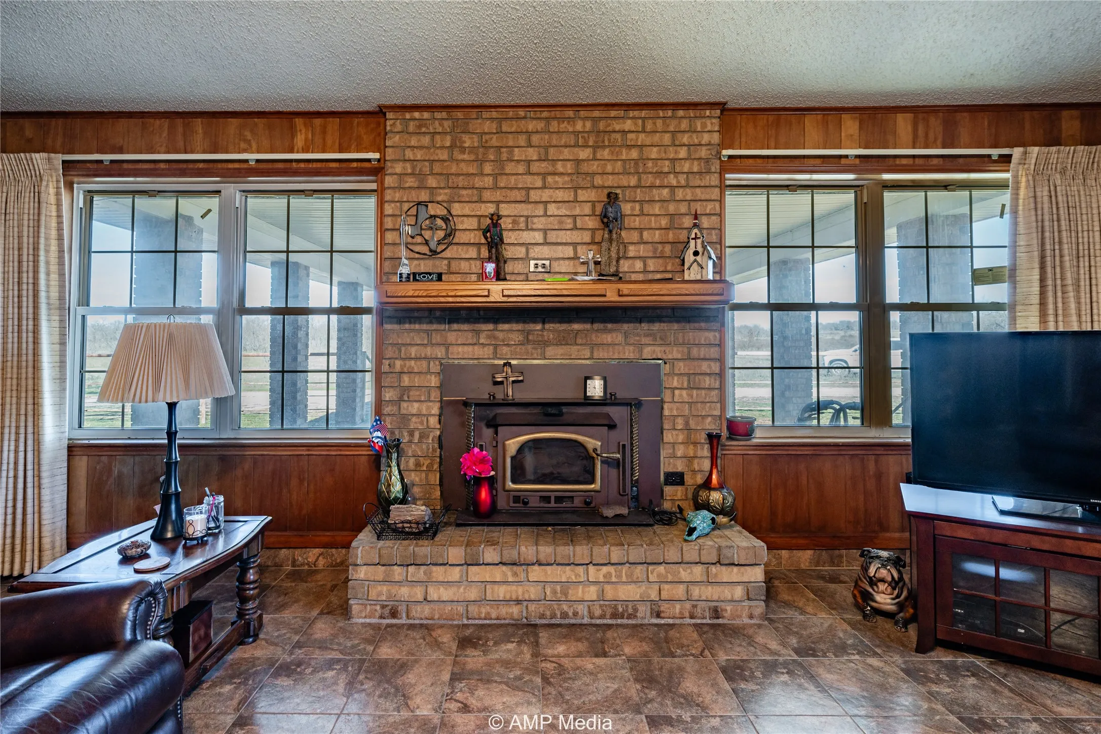Living room featuring a textured ceiling and wood walls