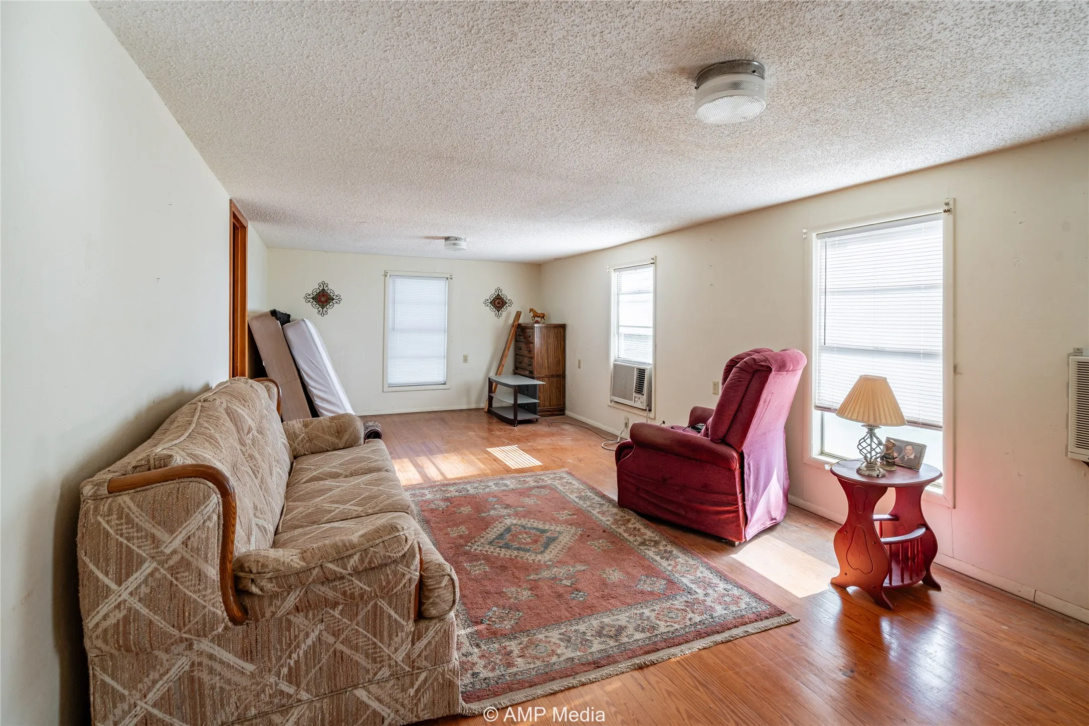 Living room featuring a textured ceiling and light hardwood / wood-style floors
