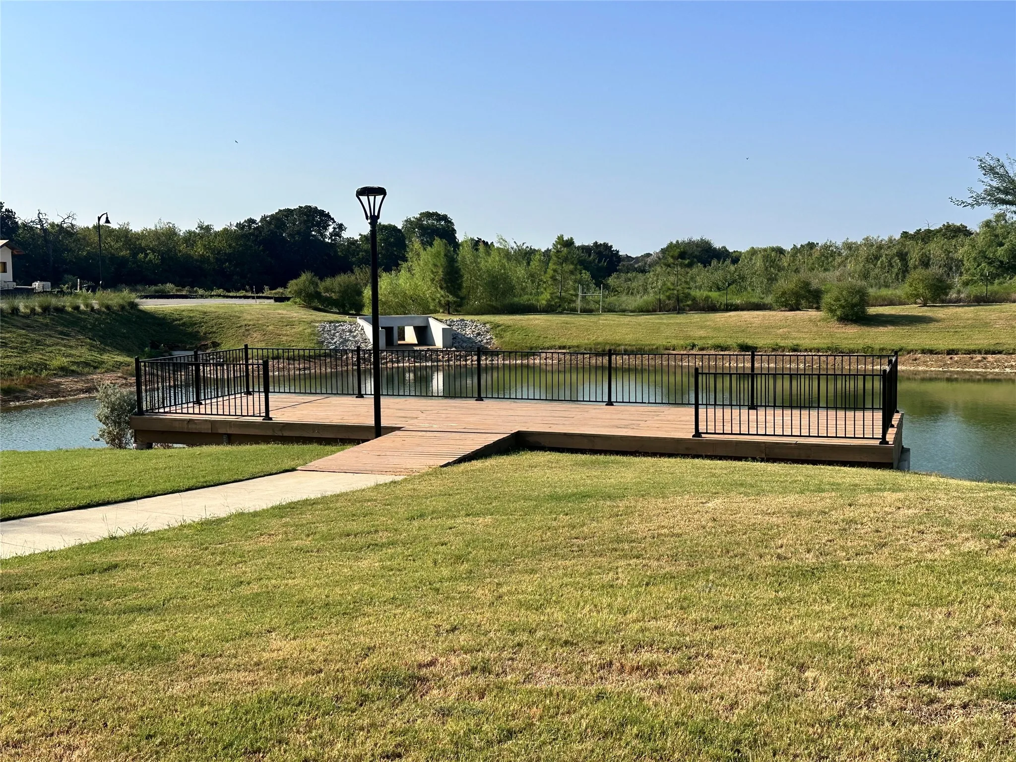 Waterside deck with black metal railing and natural landscaping