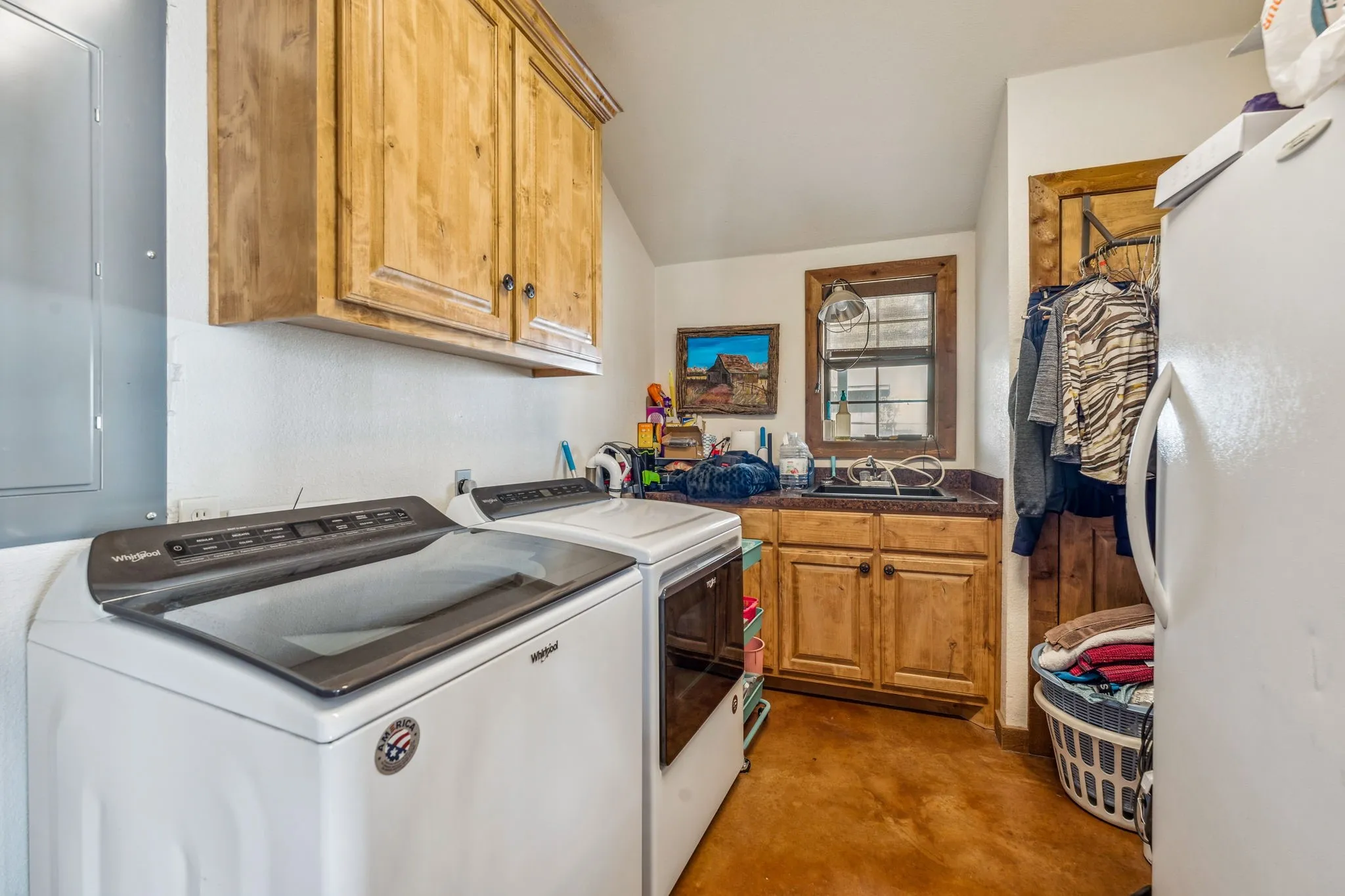 Washroom with independent washer and dryer, a sink, and cabinet space