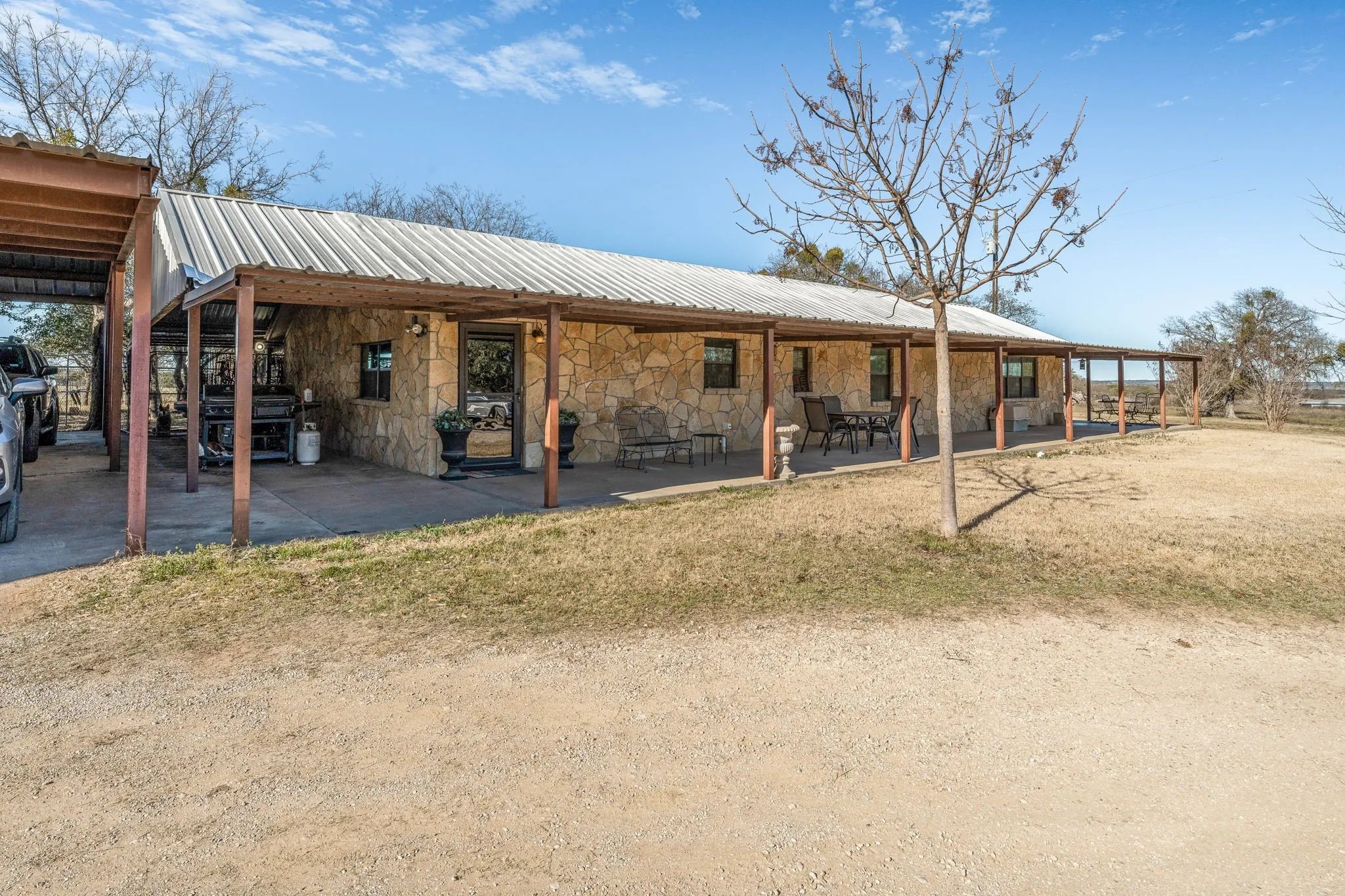 Back of property featuring metal roof and stone siding
