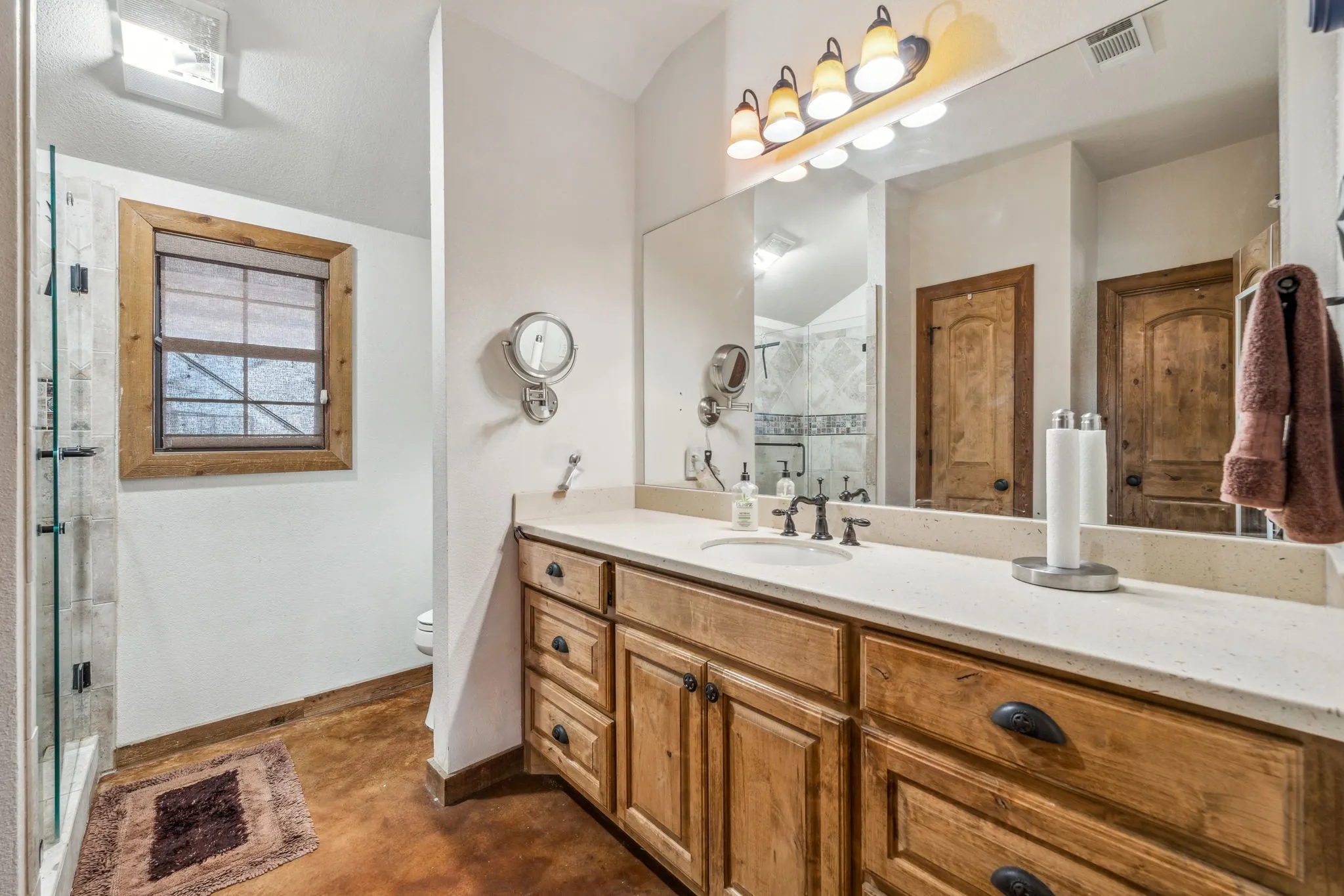 Full bath with visible vents, toilet, a shower stall, vanity, and baseboards