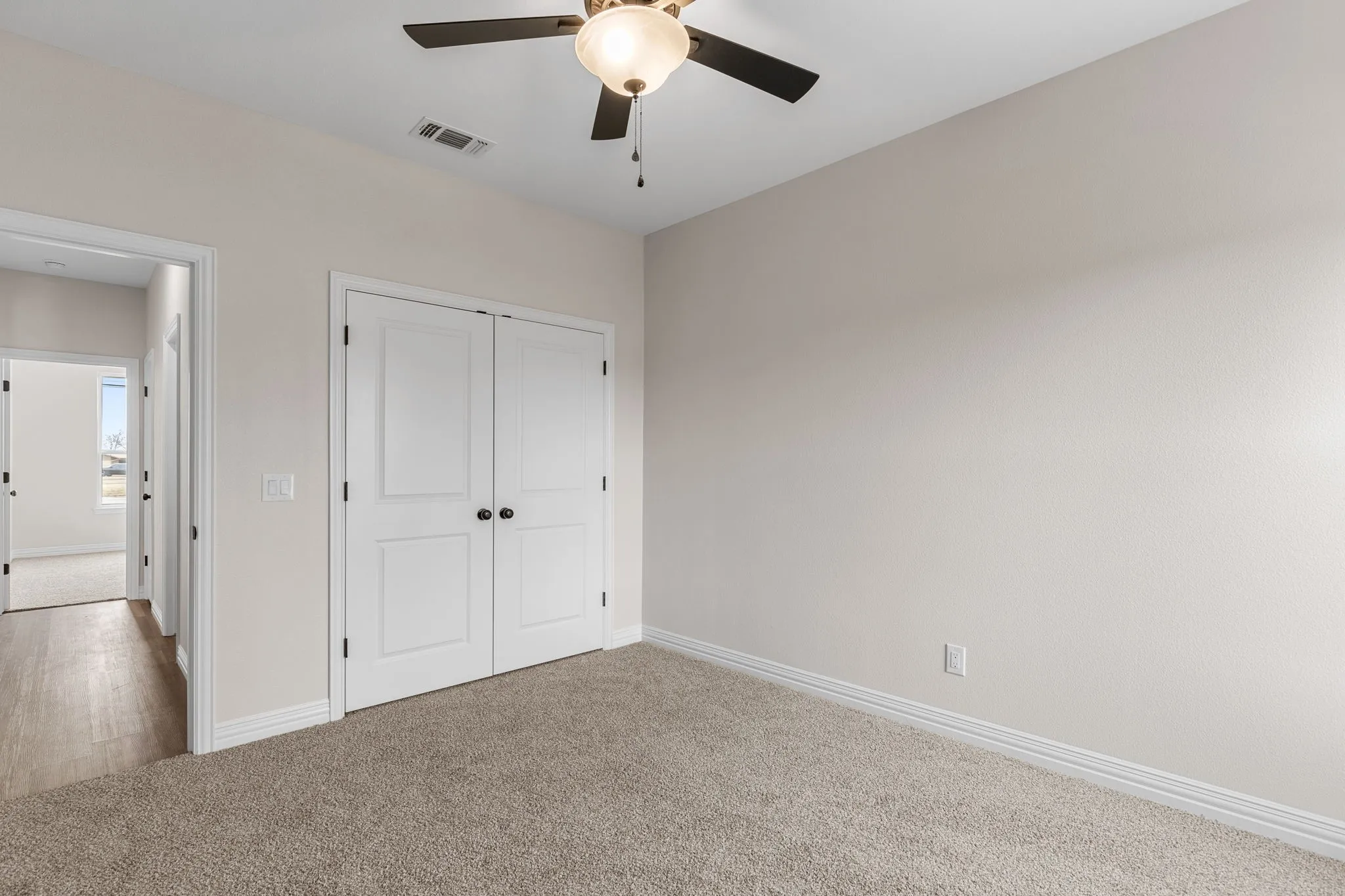 Unfurnished bedroom featuring carpet, ceiling fan, and a closet