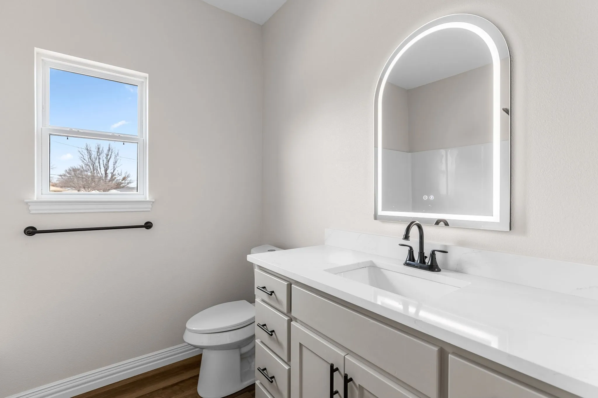 Bathroom featuring walk in shower, vanity, toilet, and hardwood / wood-style floors