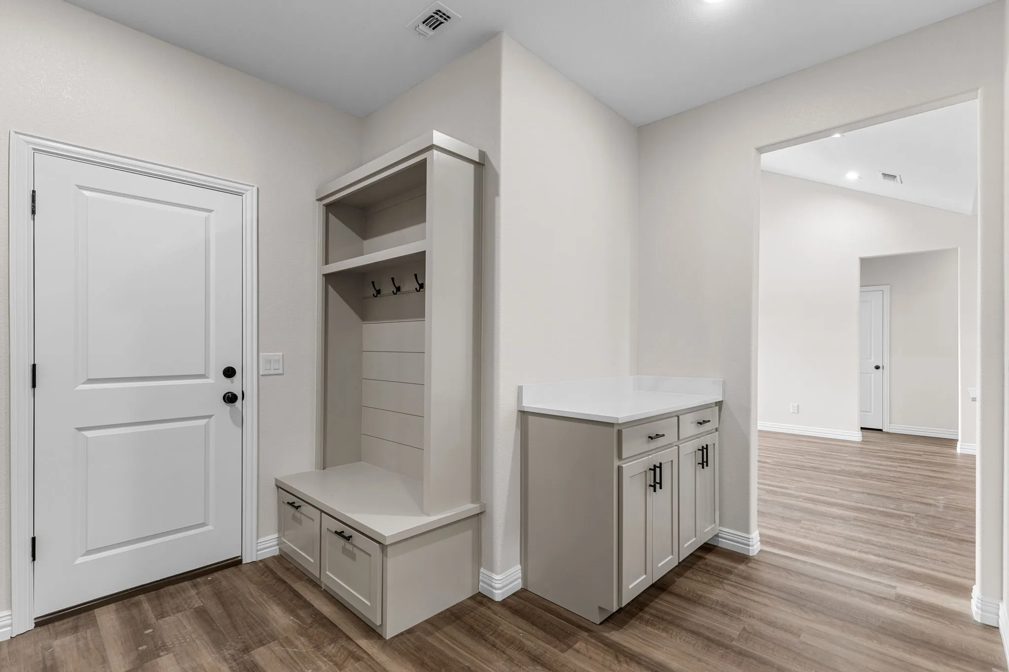 Mudroom featuring hardwood / wood-style floors and vaulted ceiling
