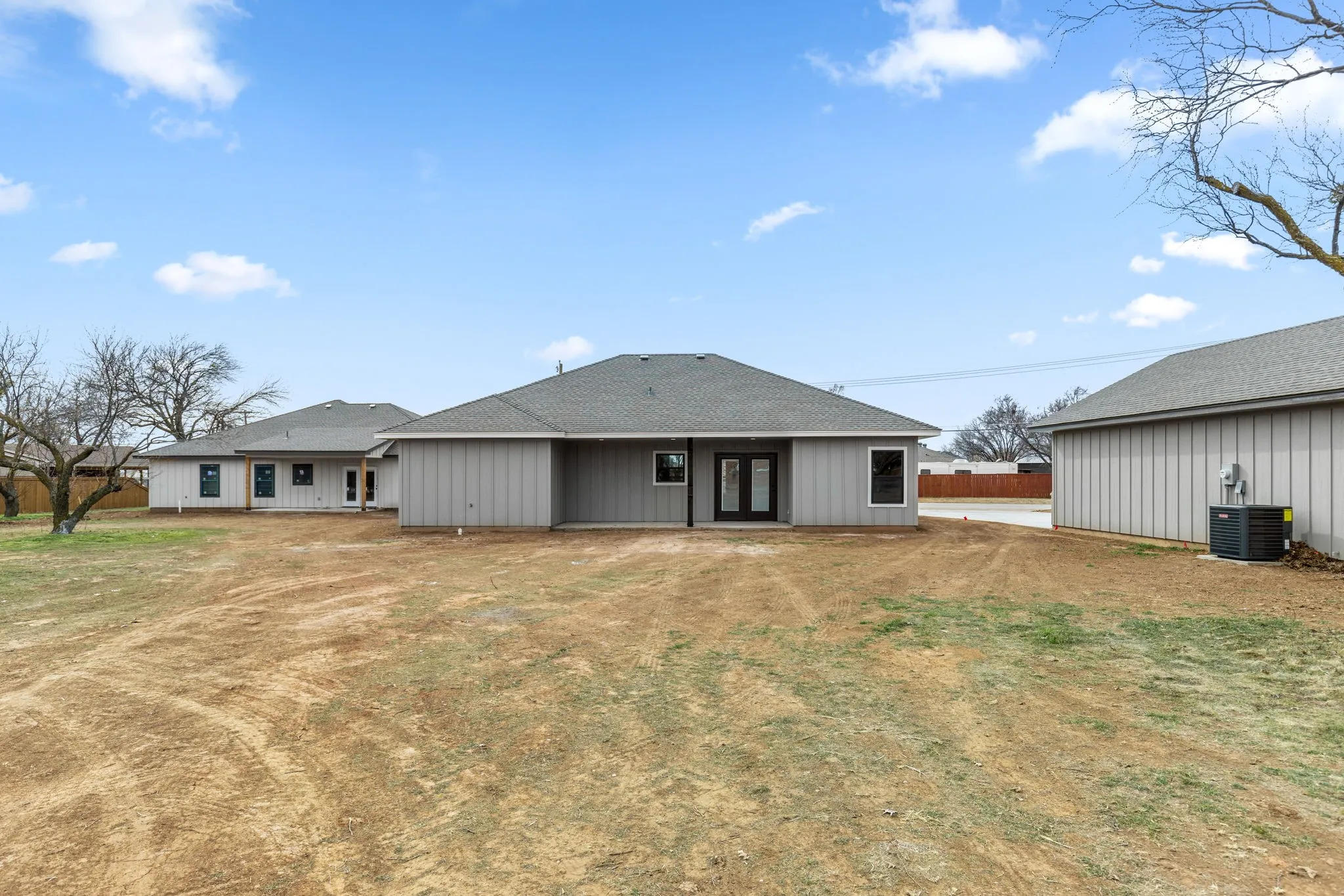Back of property featuring central AC and a lawn