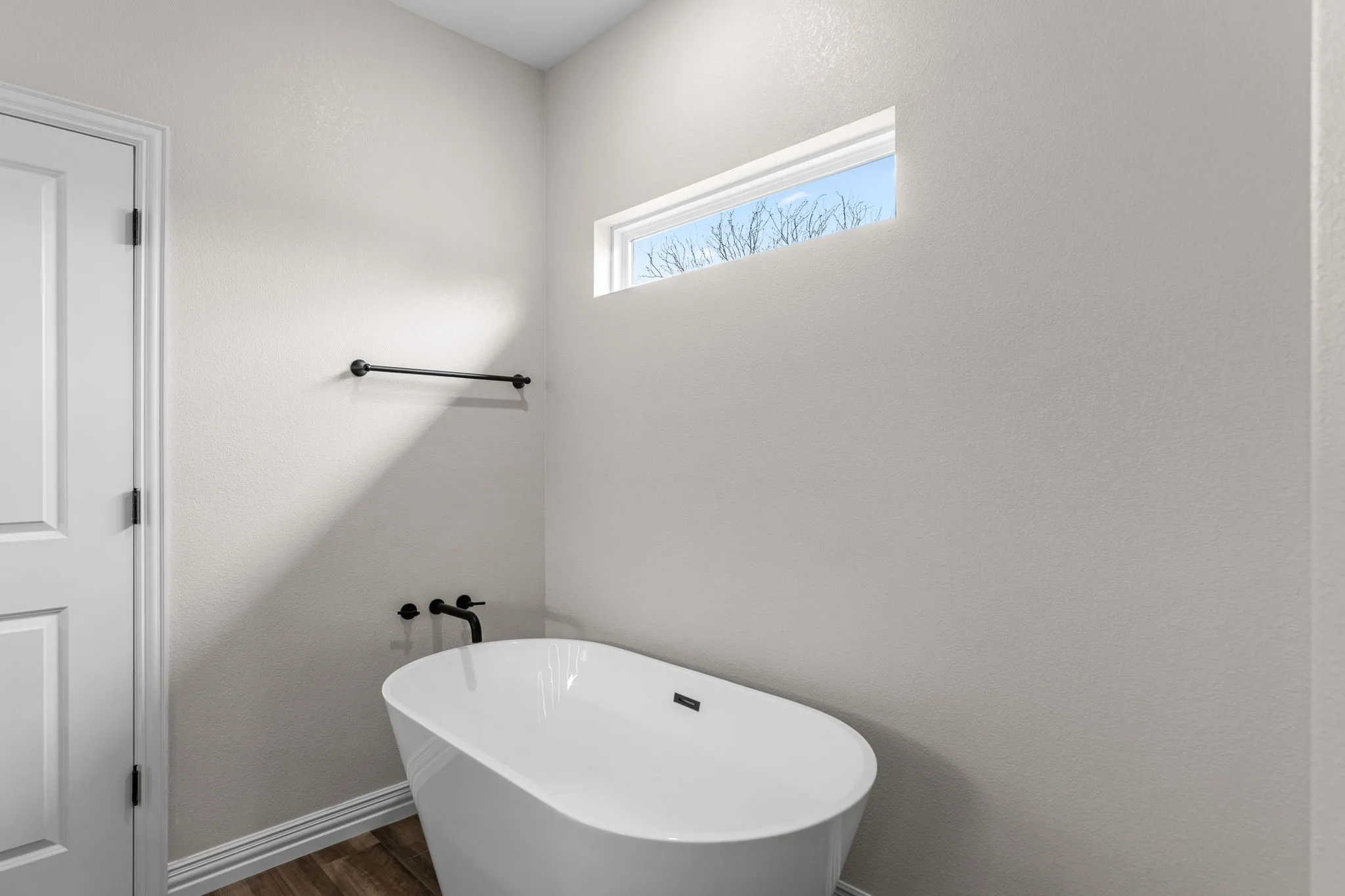 Bathroom featuring a washtub and wood-type flooring