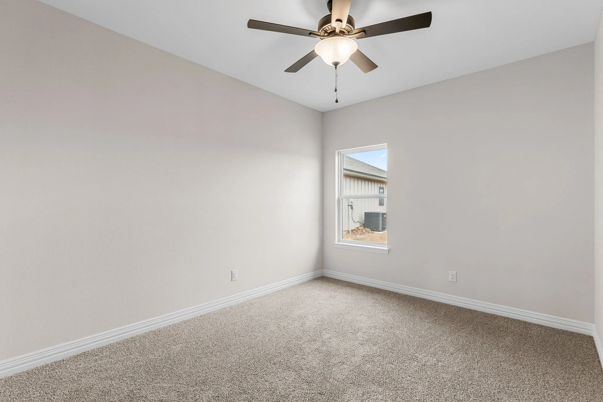 Carpeted spare room featuring ceiling fan
