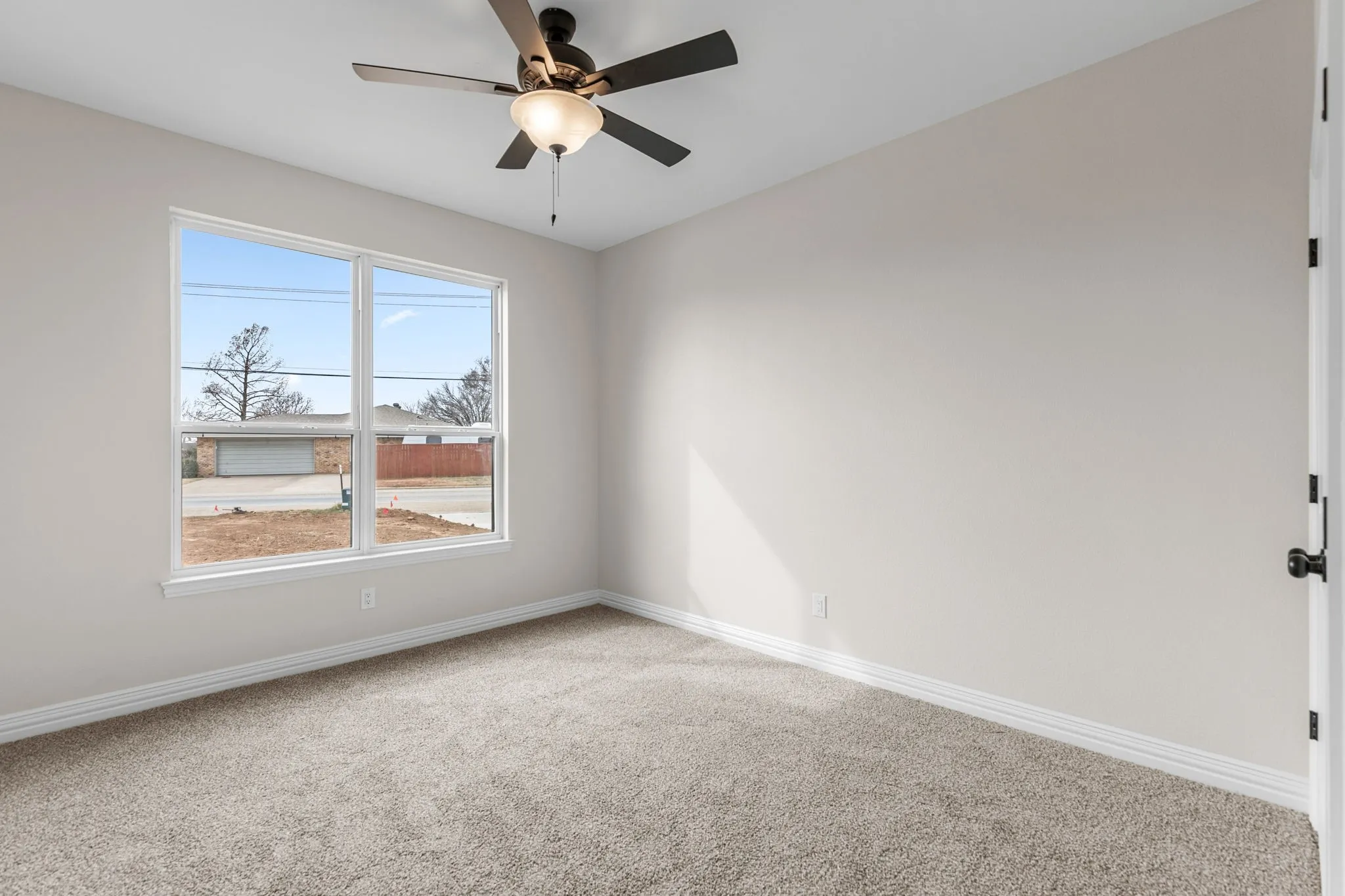 Unfurnished room featuring ceiling fan and carpet