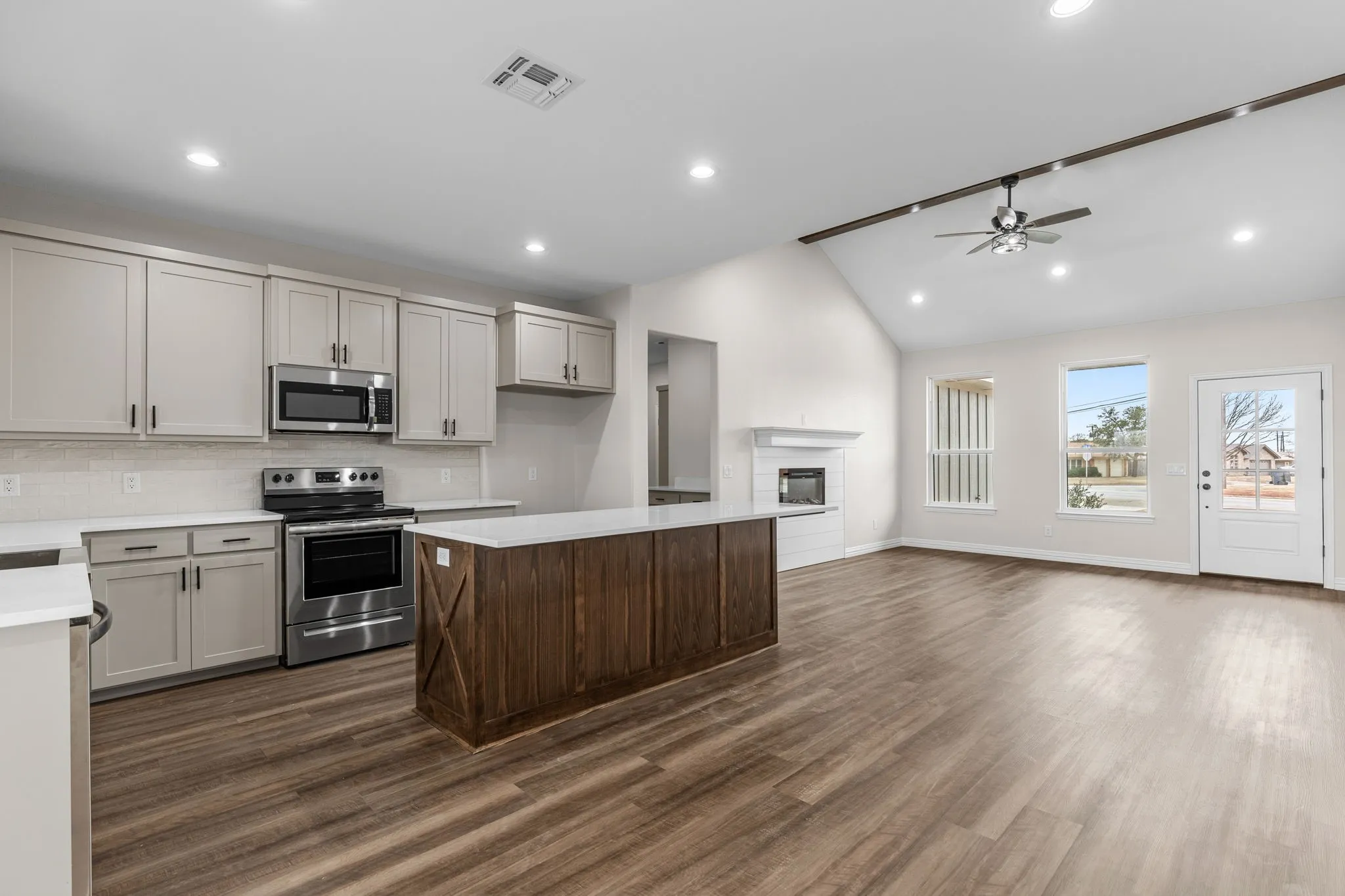 Kitchen with lofted ceiling, tasteful backsplash, stainless steel appliances, and a kitchen island