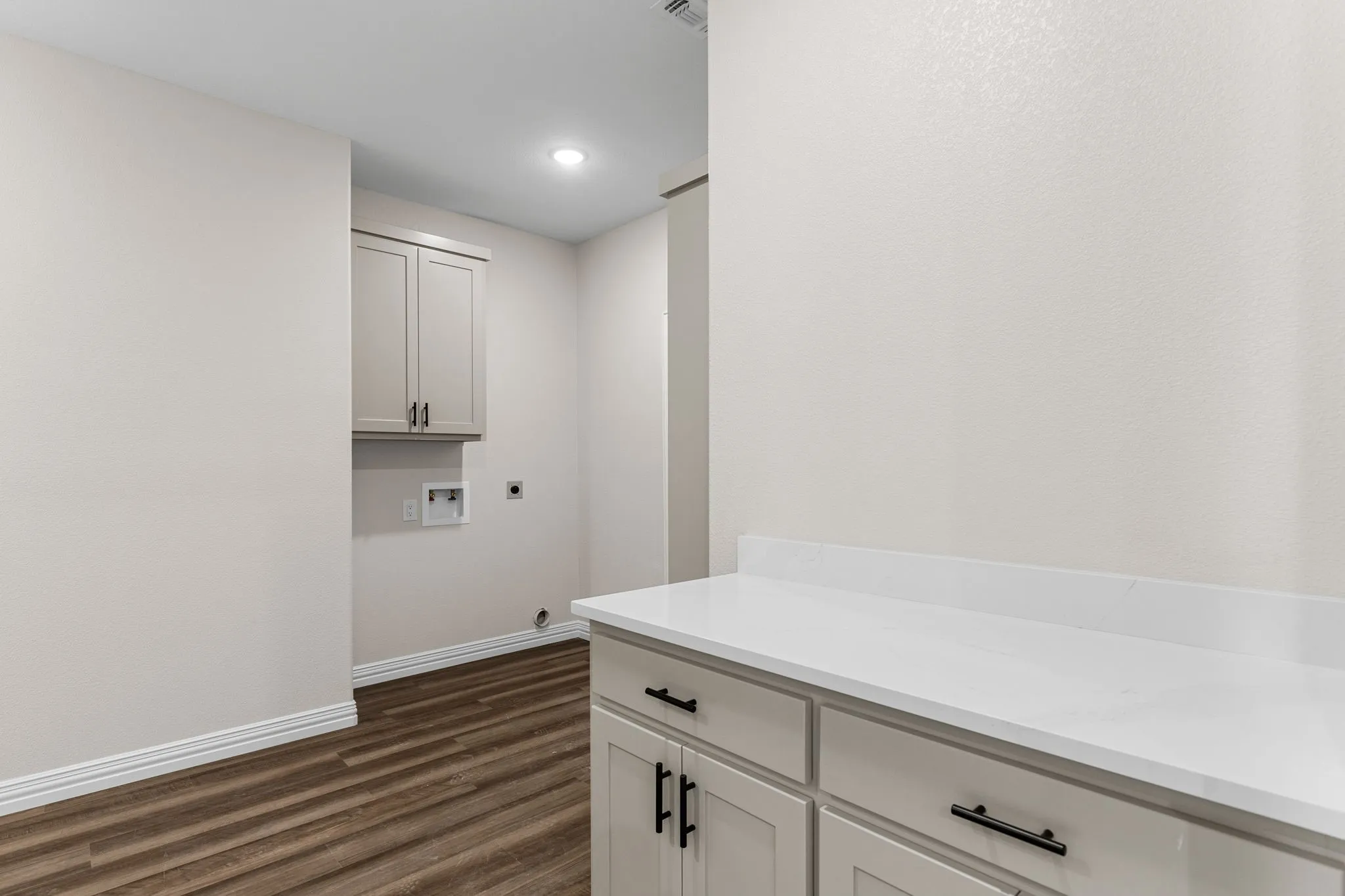 Washroom featuring hookup for a washing machine, dark hardwood / wood-style floors, hookup for an electric dryer, and cabinets
