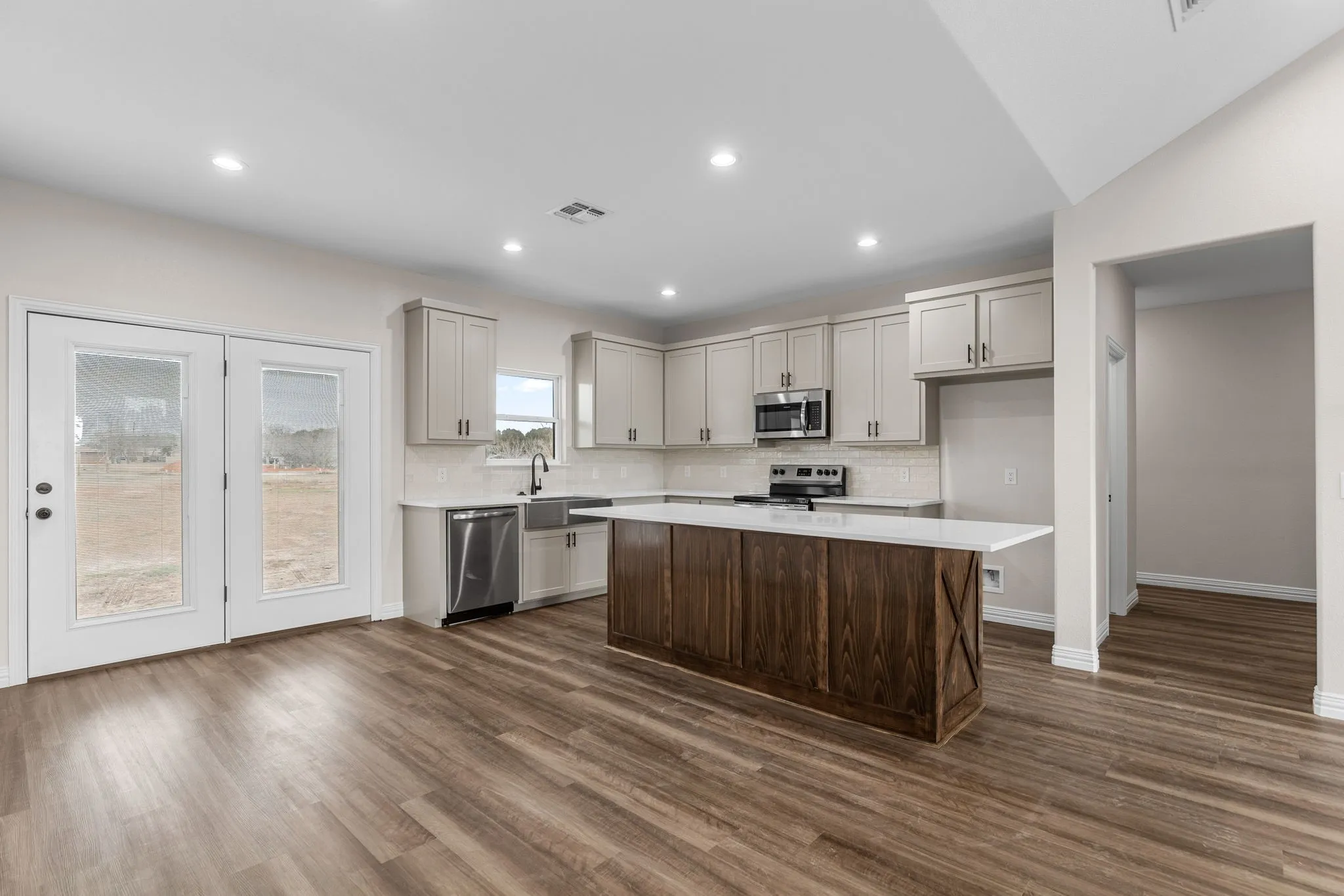 Kitchen with a kitchen island, appliances with stainless steel finishes, sink, and dark hardwood / wood-style floors