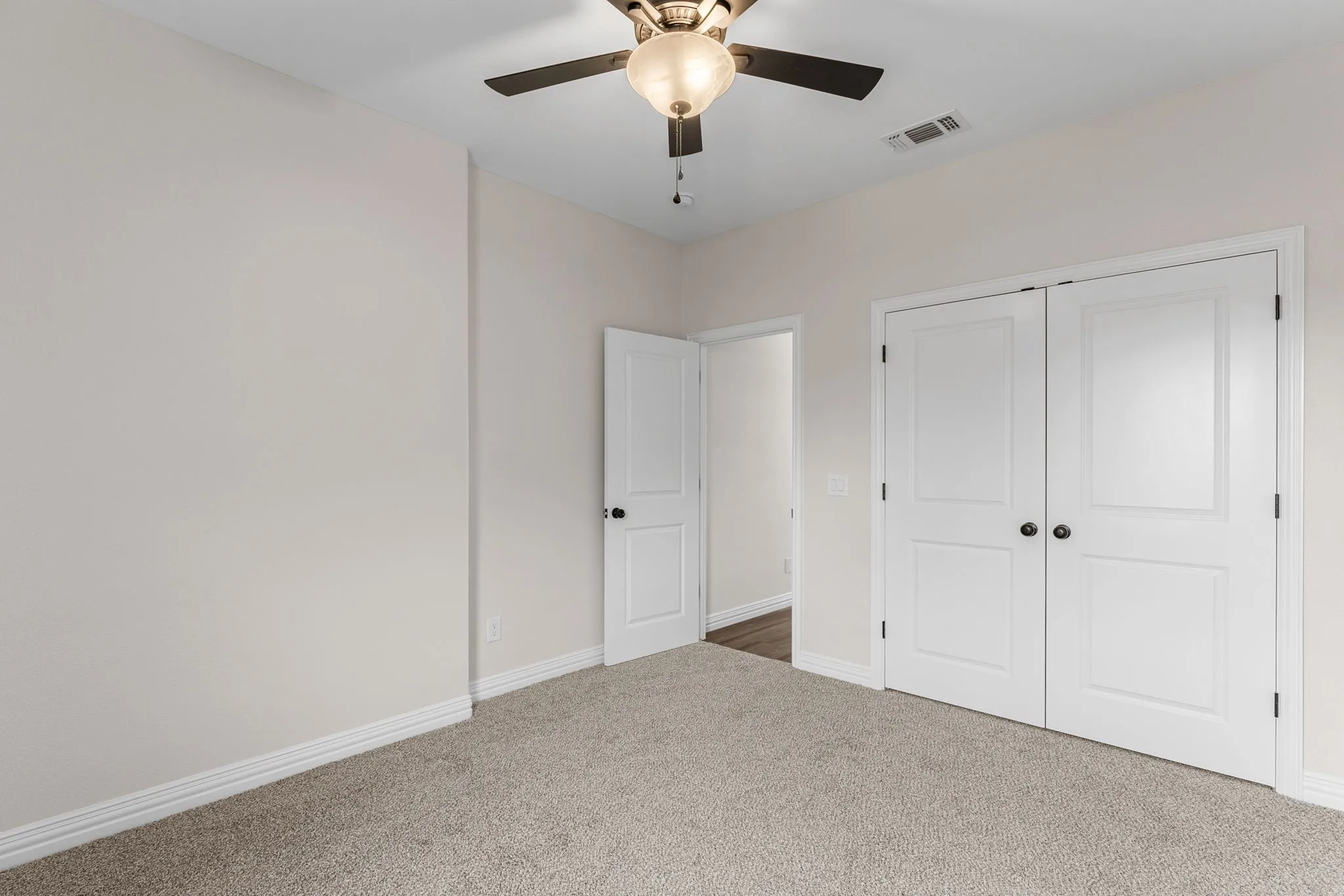 Unfurnished bedroom featuring a closet, ceiling fan, and carpet flooring