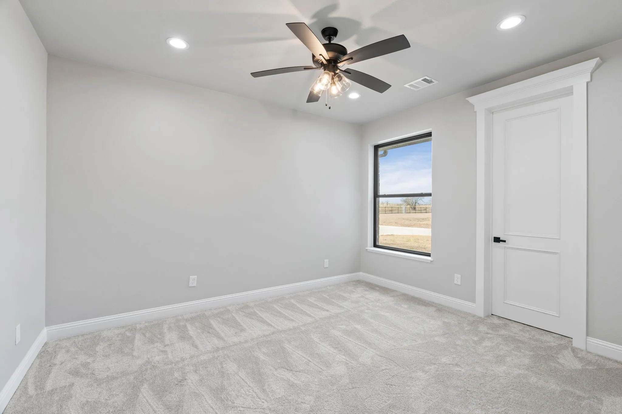 Carpeted spare room with ceiling fan