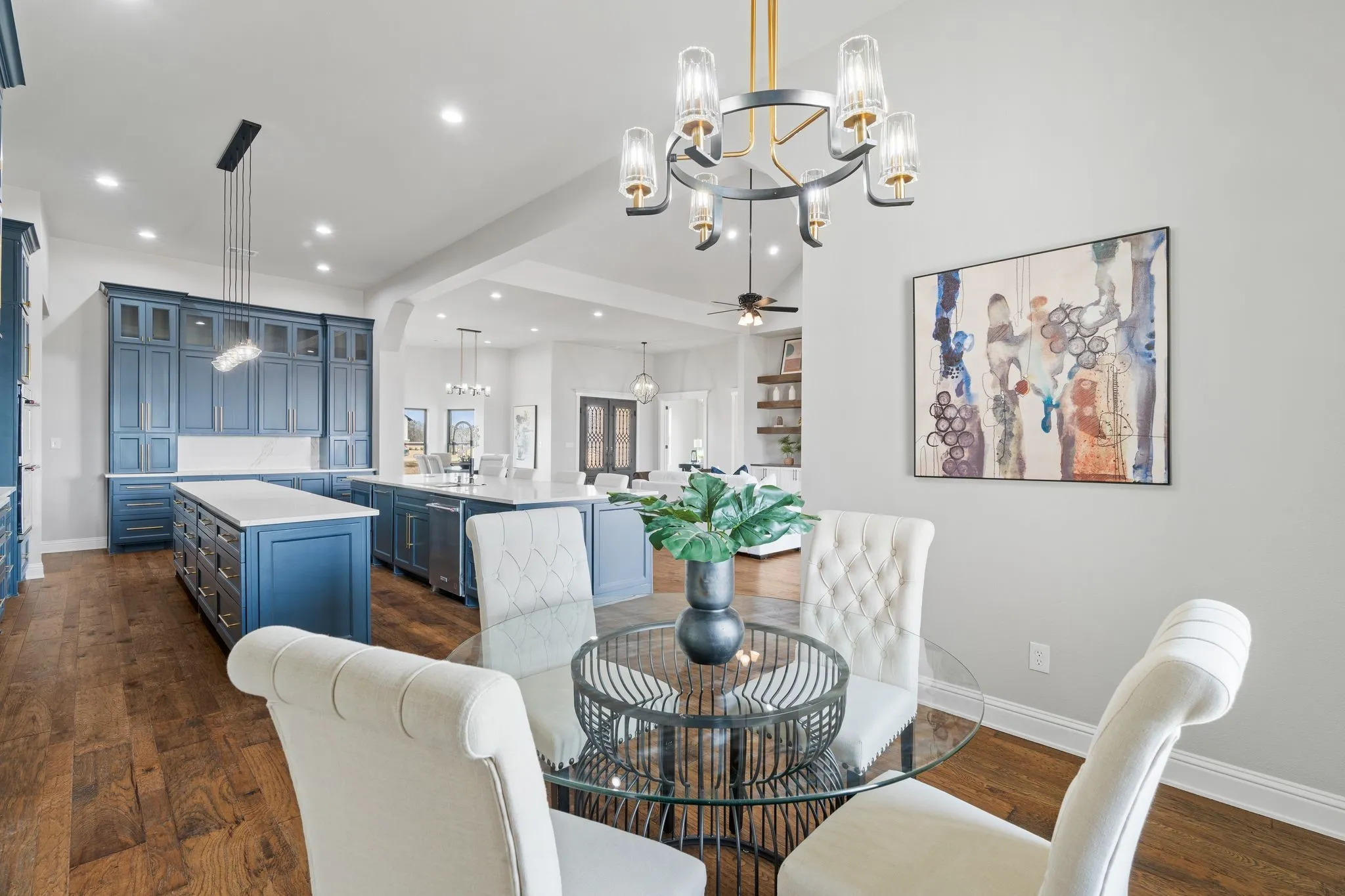 Dining space featuring ceiling fan with notable chandelier, sink, and dark hardwood / wood-style floors