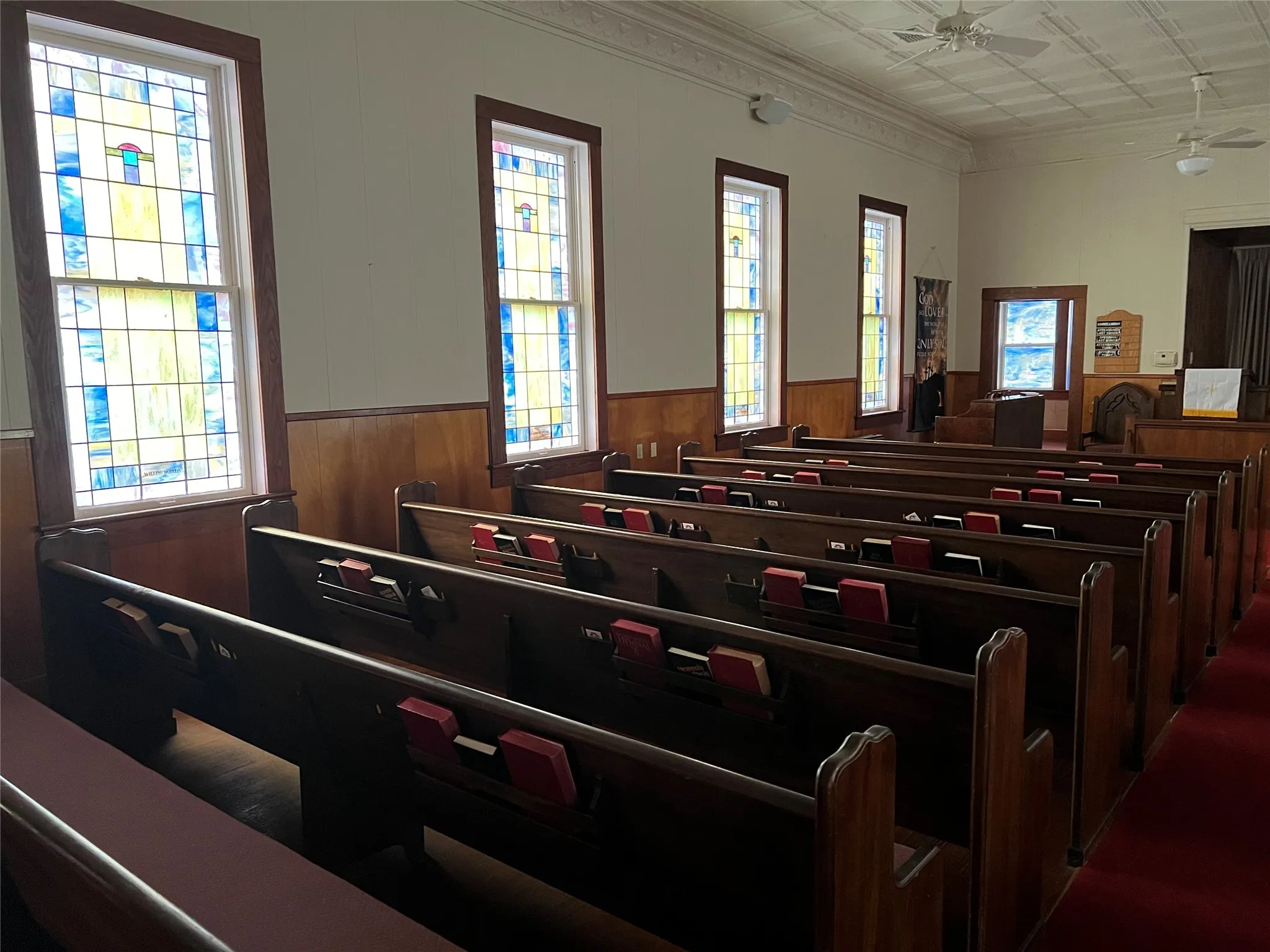 Former sanctuary with bank of stained-glass windows