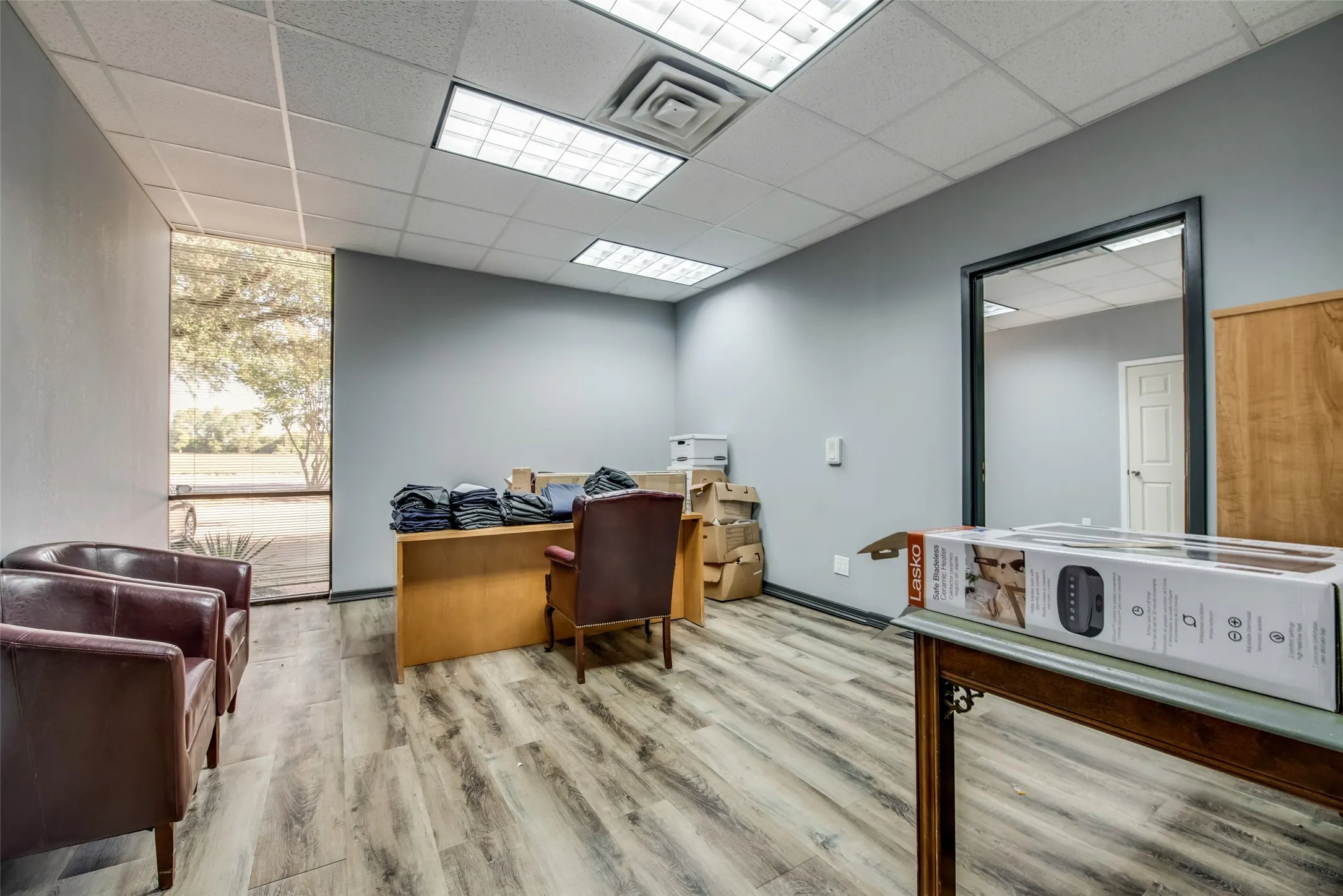 Office featuring light hardwood / wood-style flooring, floor to ceiling windows, and a paneled ceiling