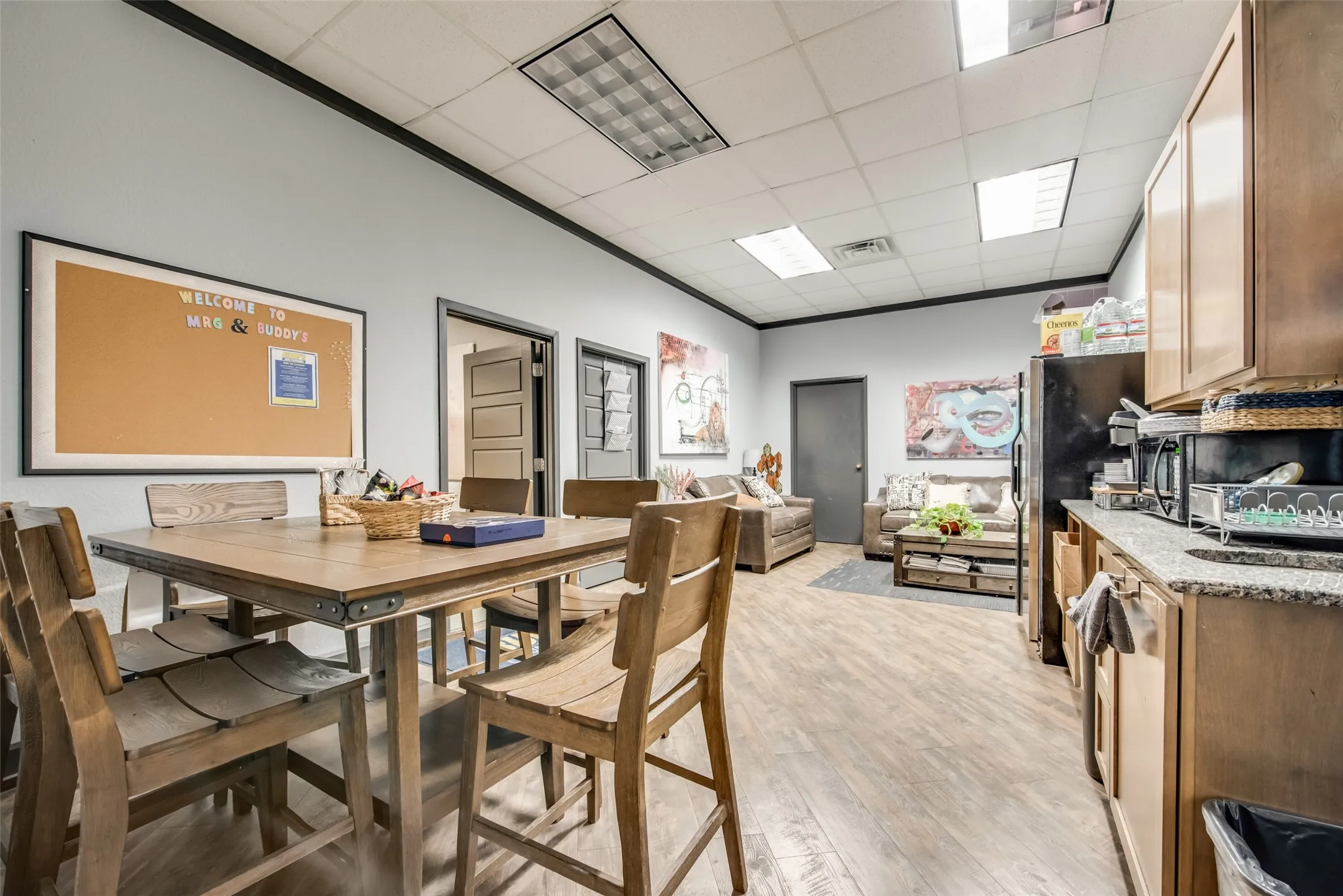 Dining area with a paneled ceiling and light wood-type flooring