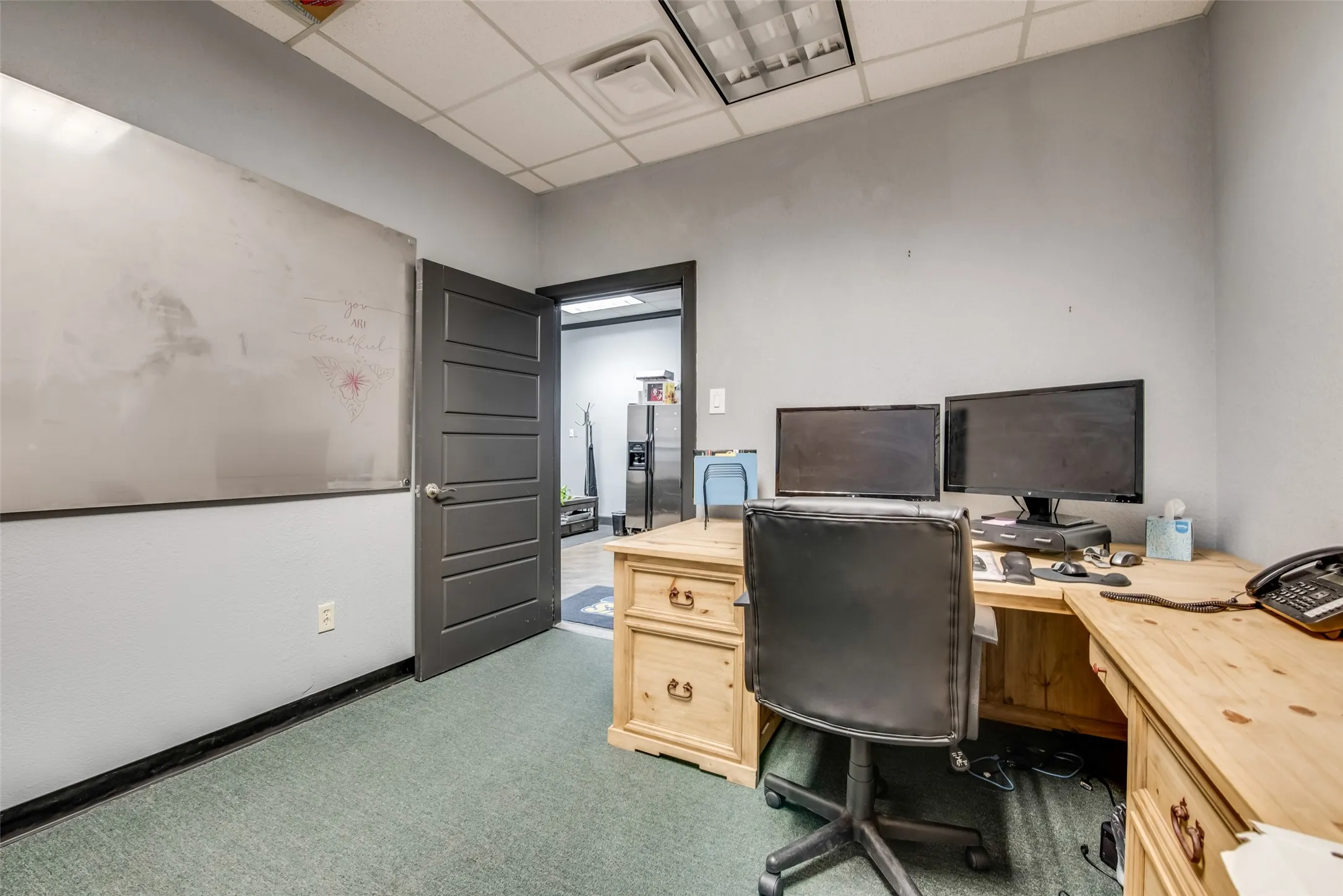 Carpeted home office with a drop ceiling