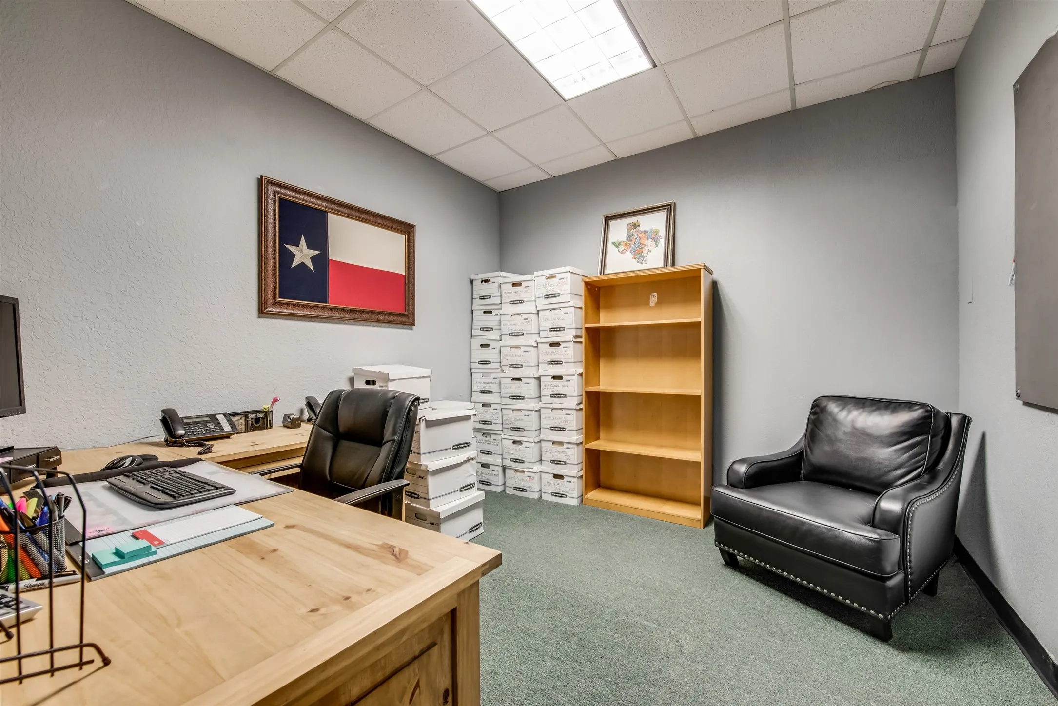 Carpeted office space with a drop ceiling