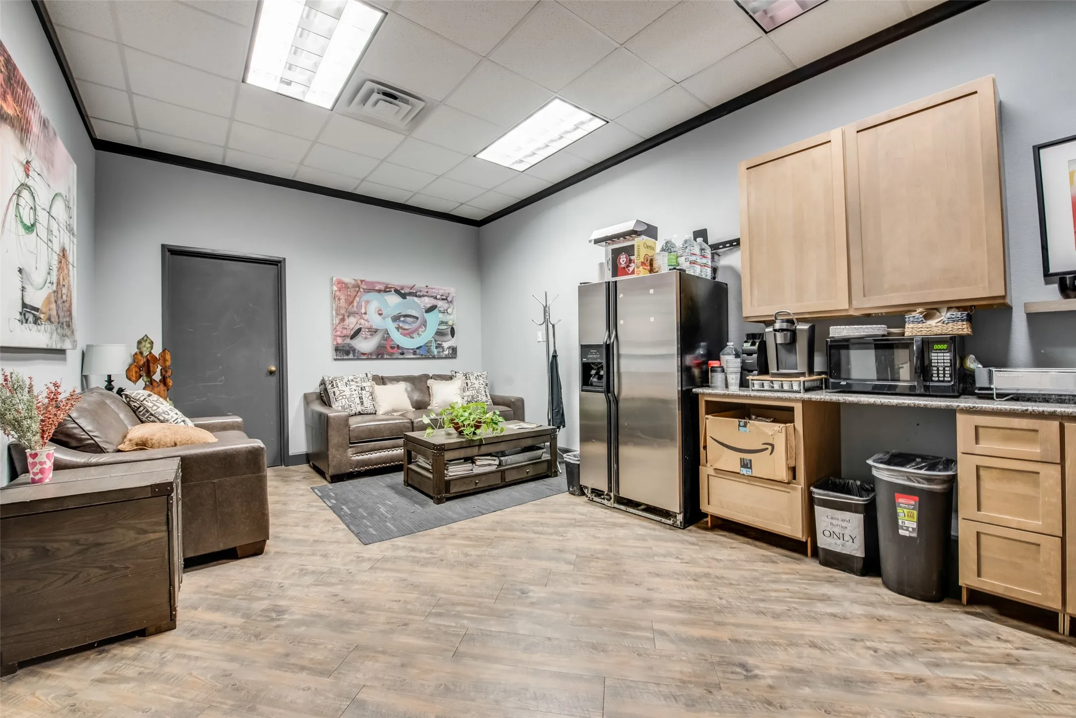 Kitchen featuring crown molding, a drop ceiling, light brown cabinetry, stainless steel fridge with ice dispenser, and light wood-type flooring