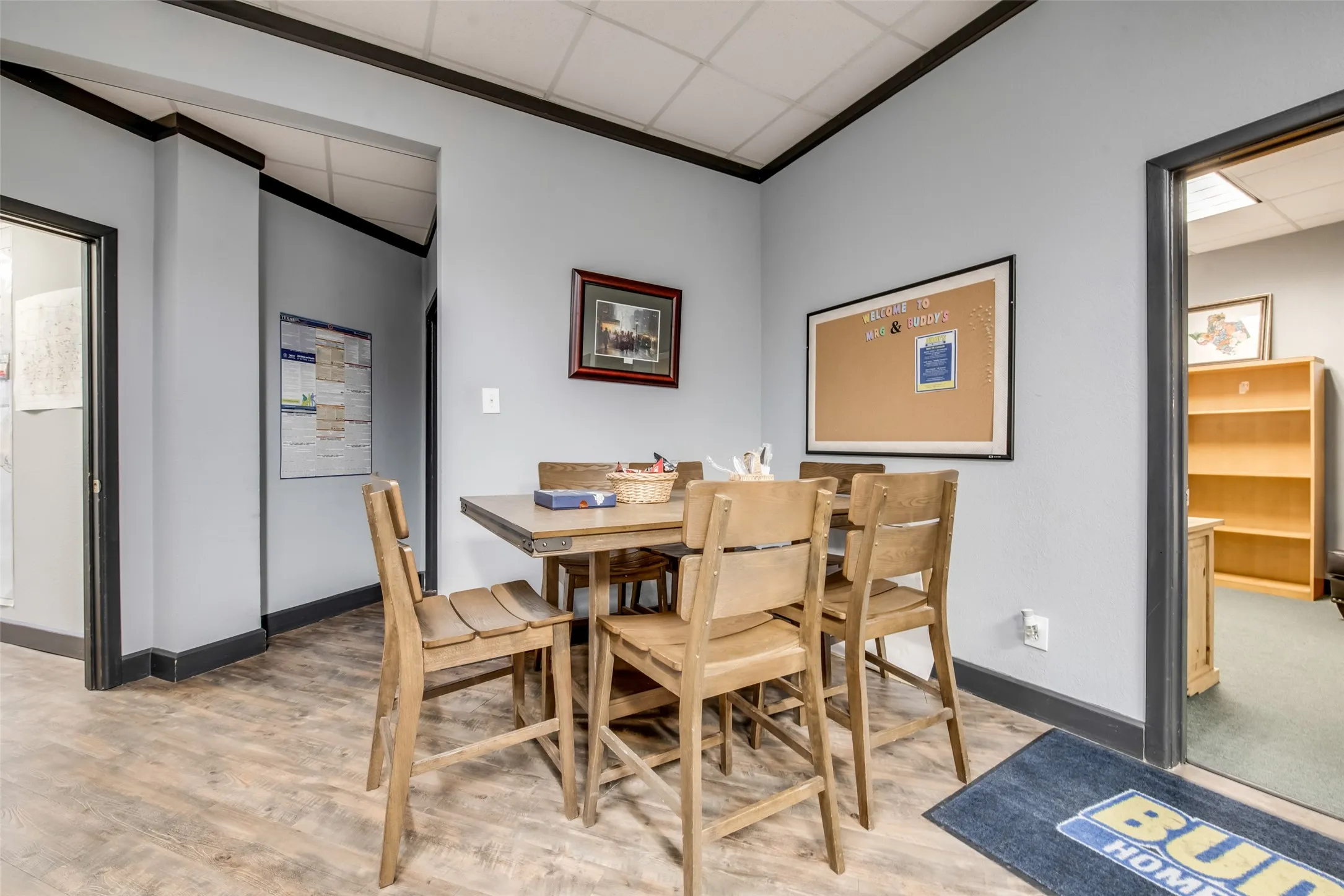 Dining space with hardwood / wood-style flooring, crown molding, and a drop ceiling