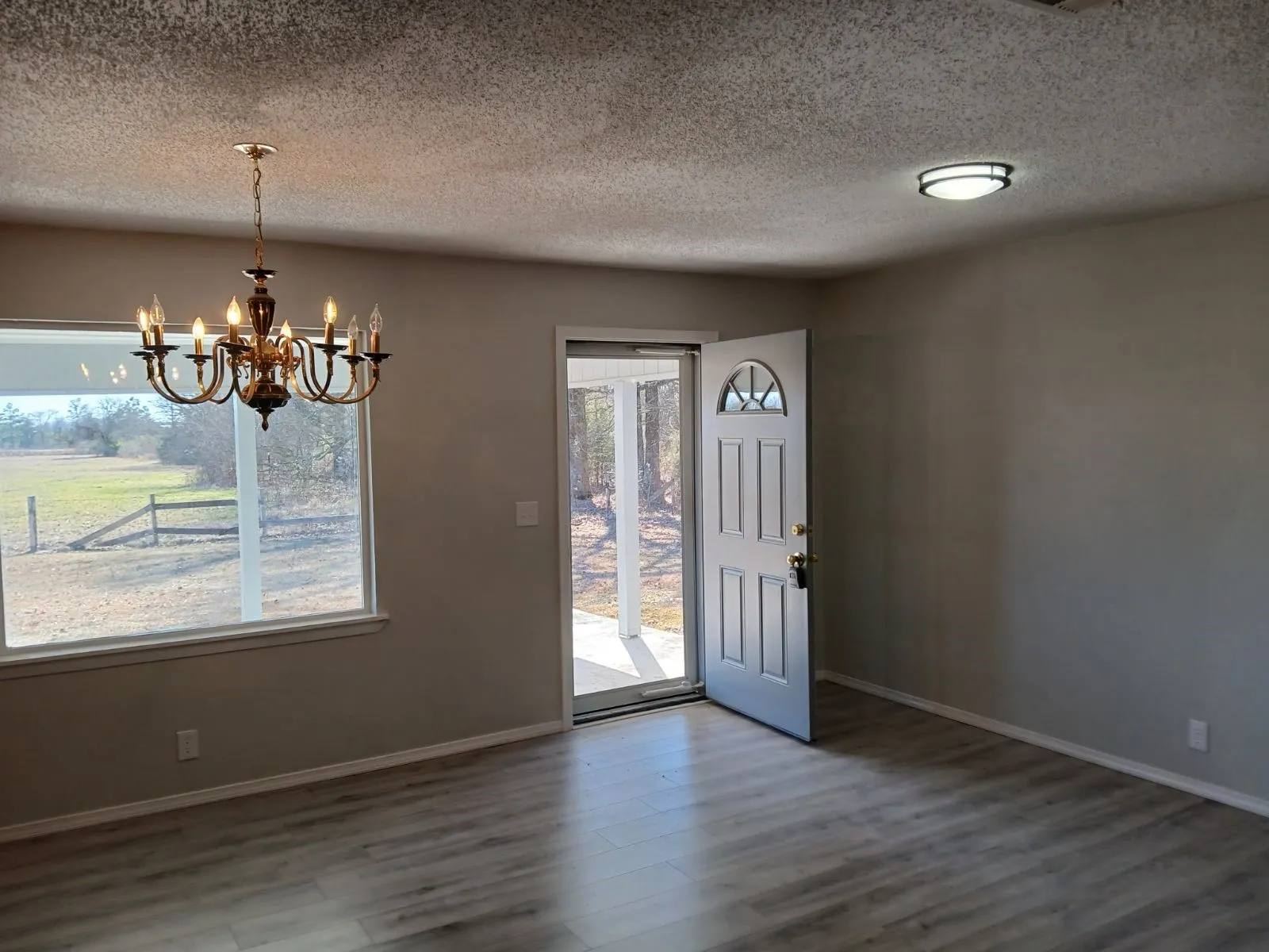 Entrance foyer with hardwood / wood-style flooring, a textured ceiling, and a chandelier