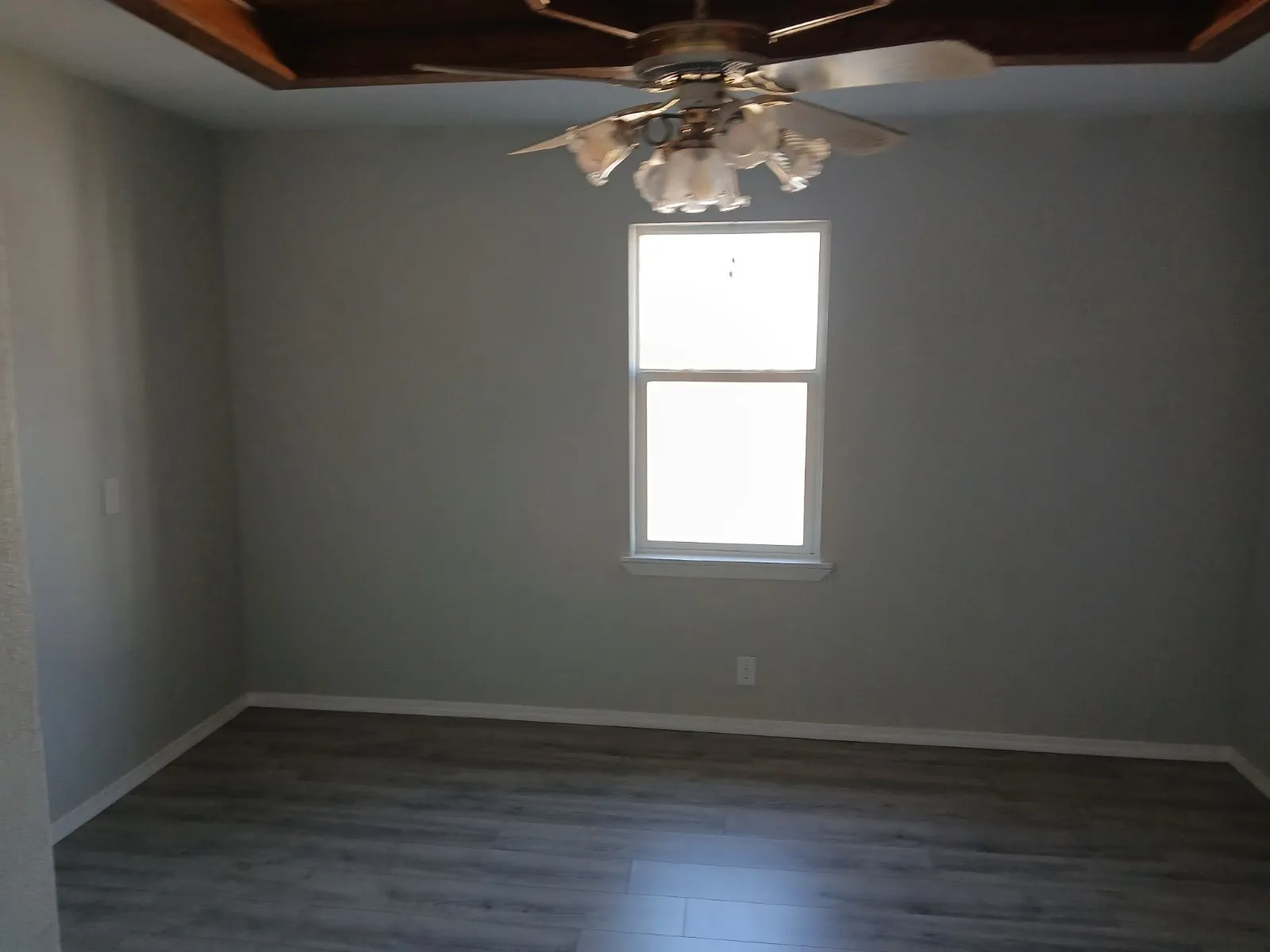 Empty room with dark hardwood / wood-style flooring and ceiling fan