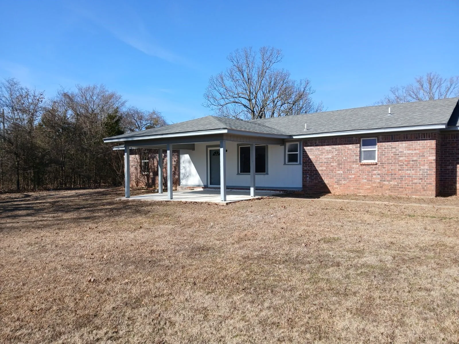Rear view of property featuring a yard and a patio area