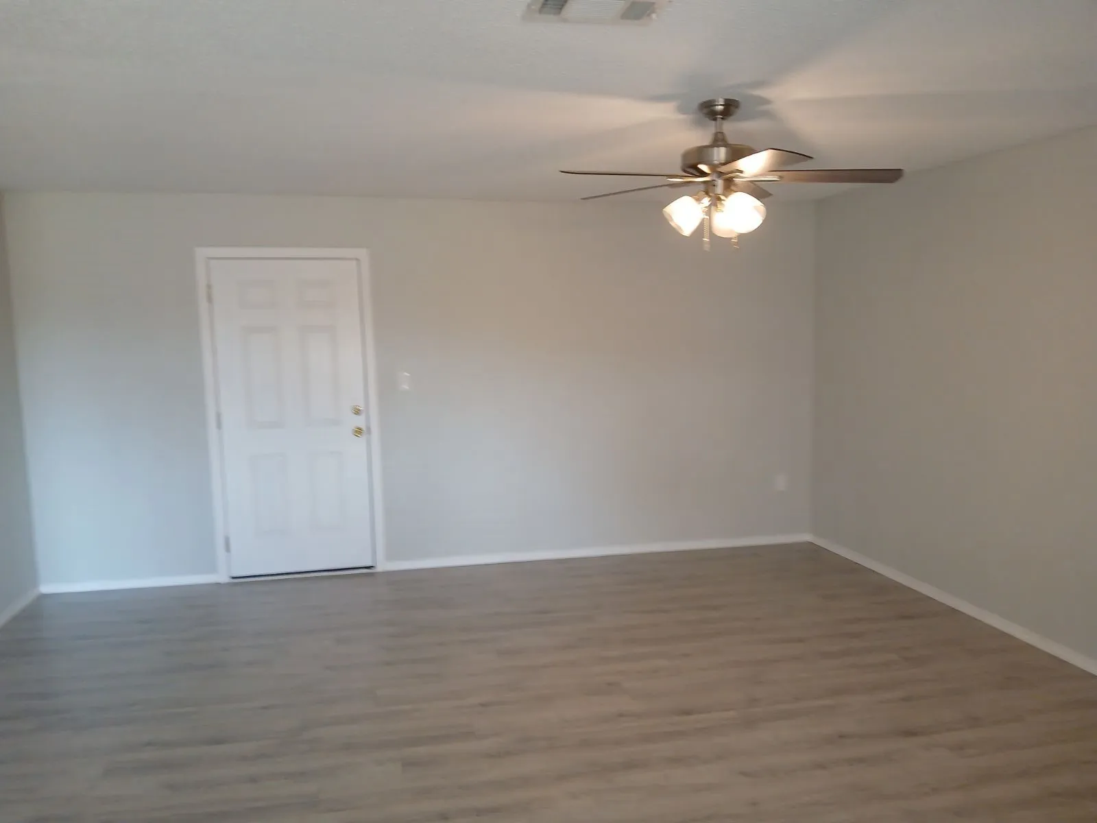 Spare room with hardwood / wood-style flooring and ceiling fan