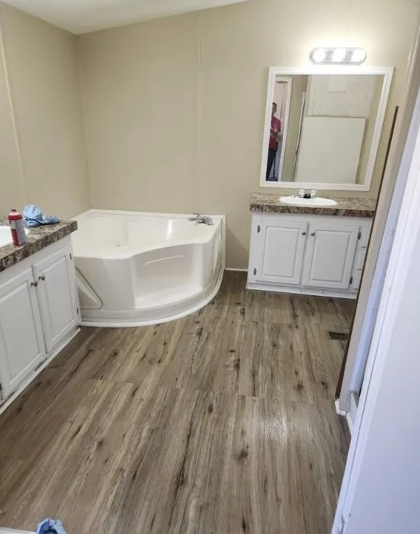 Bathroom featuring vanity, hardwood / wood-style floors, and a tub