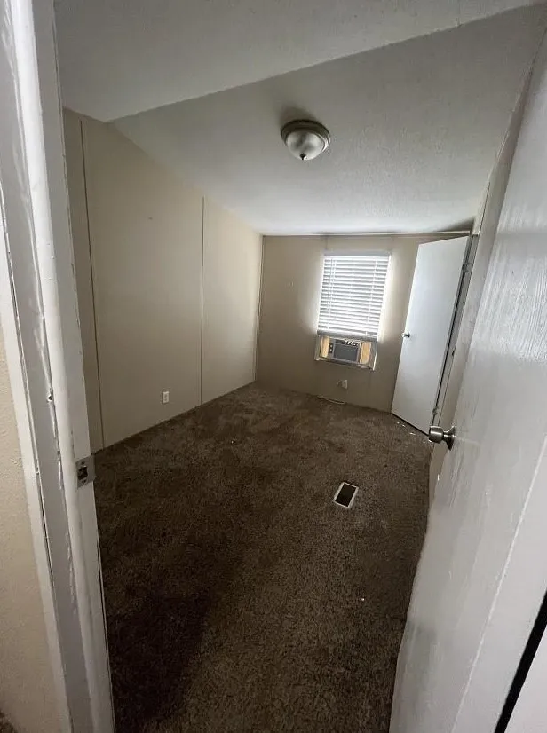 Empty room with carpet and a textured ceiling