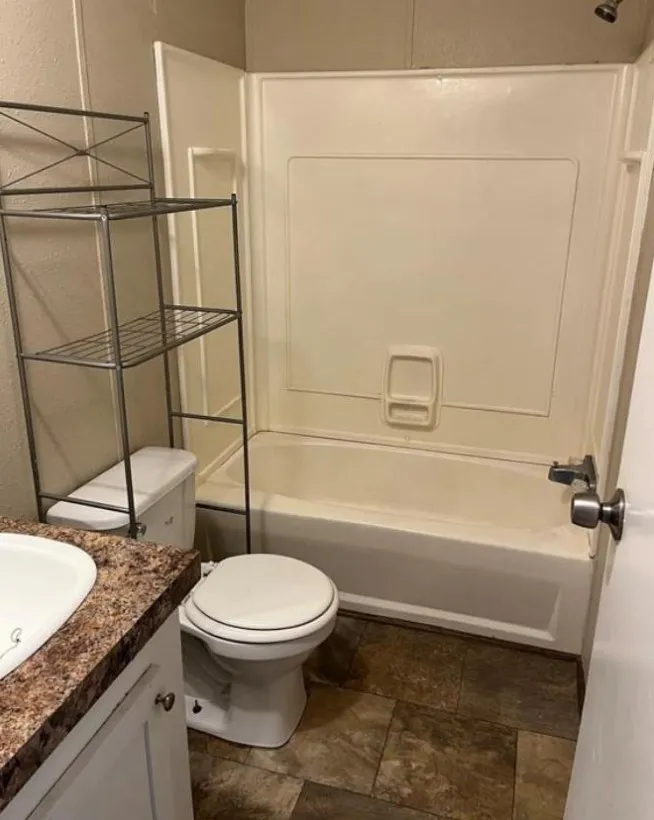 Full bathroom with tile patterned flooring, shower / bath combination, toilet, and vanity