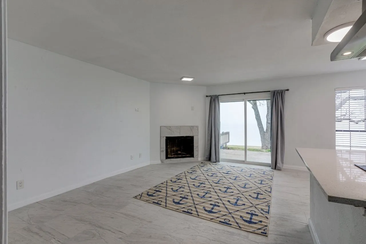 Unfurnished living room with plenty of natural light and a high end fireplace