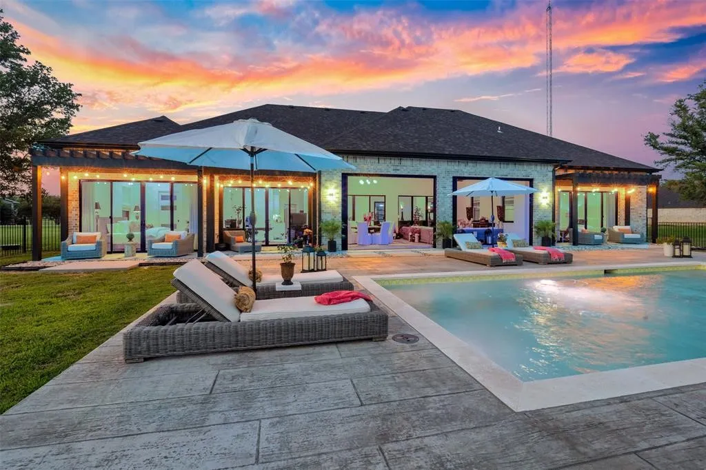 Back house at dusk featuring an outdoor hangout area and a patio