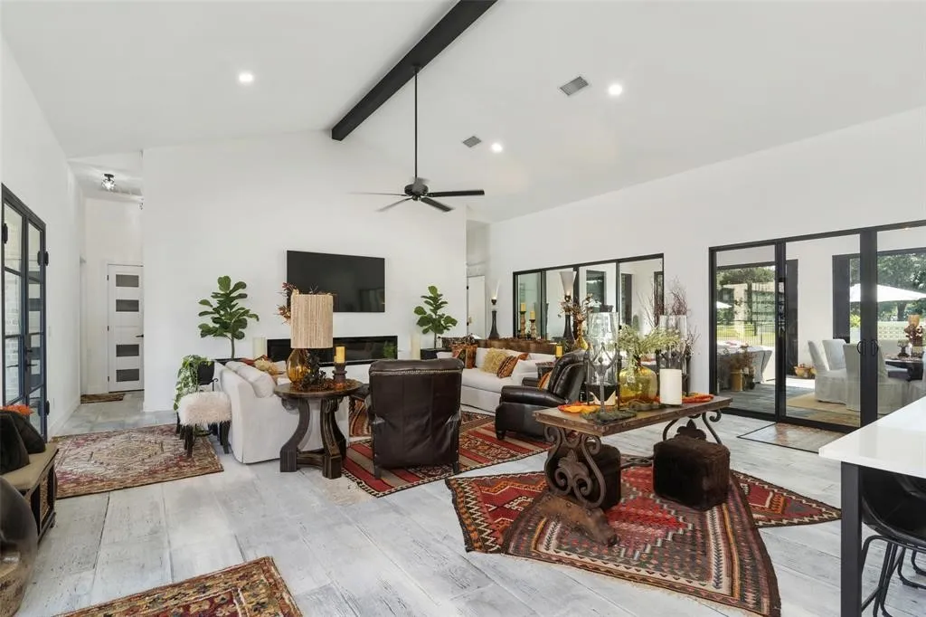 Living room with beam ceiling, light hardwood / wood-style flooring, high vaulted ceiling, and french doors